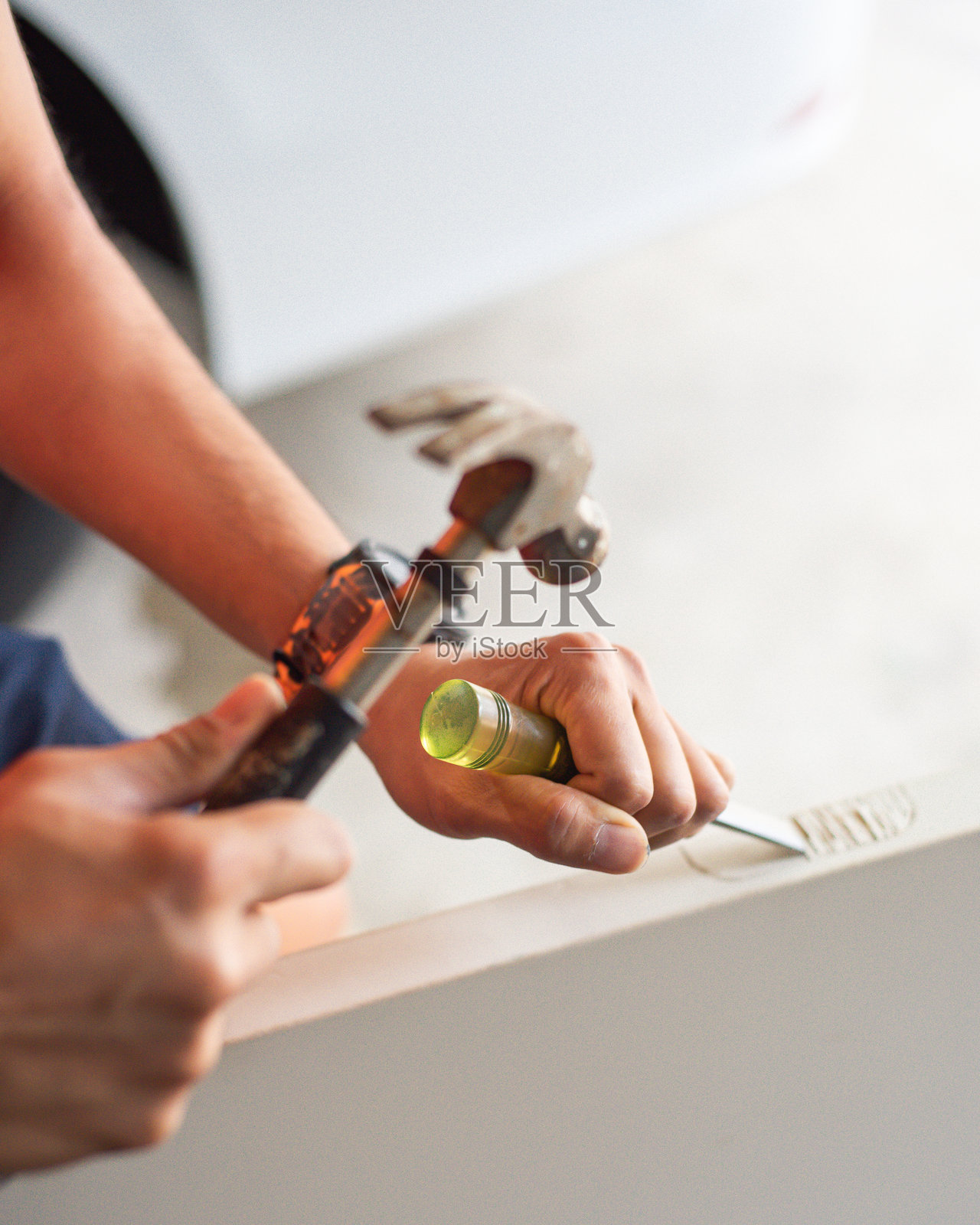 工匠开始在一扇白漆门板上凿刻，制作合适的锁舌板和铰链叶，展现出木材中的裂缝和沟槽，捕捉原材料与熟练转变之间的张力。照片摄影图片