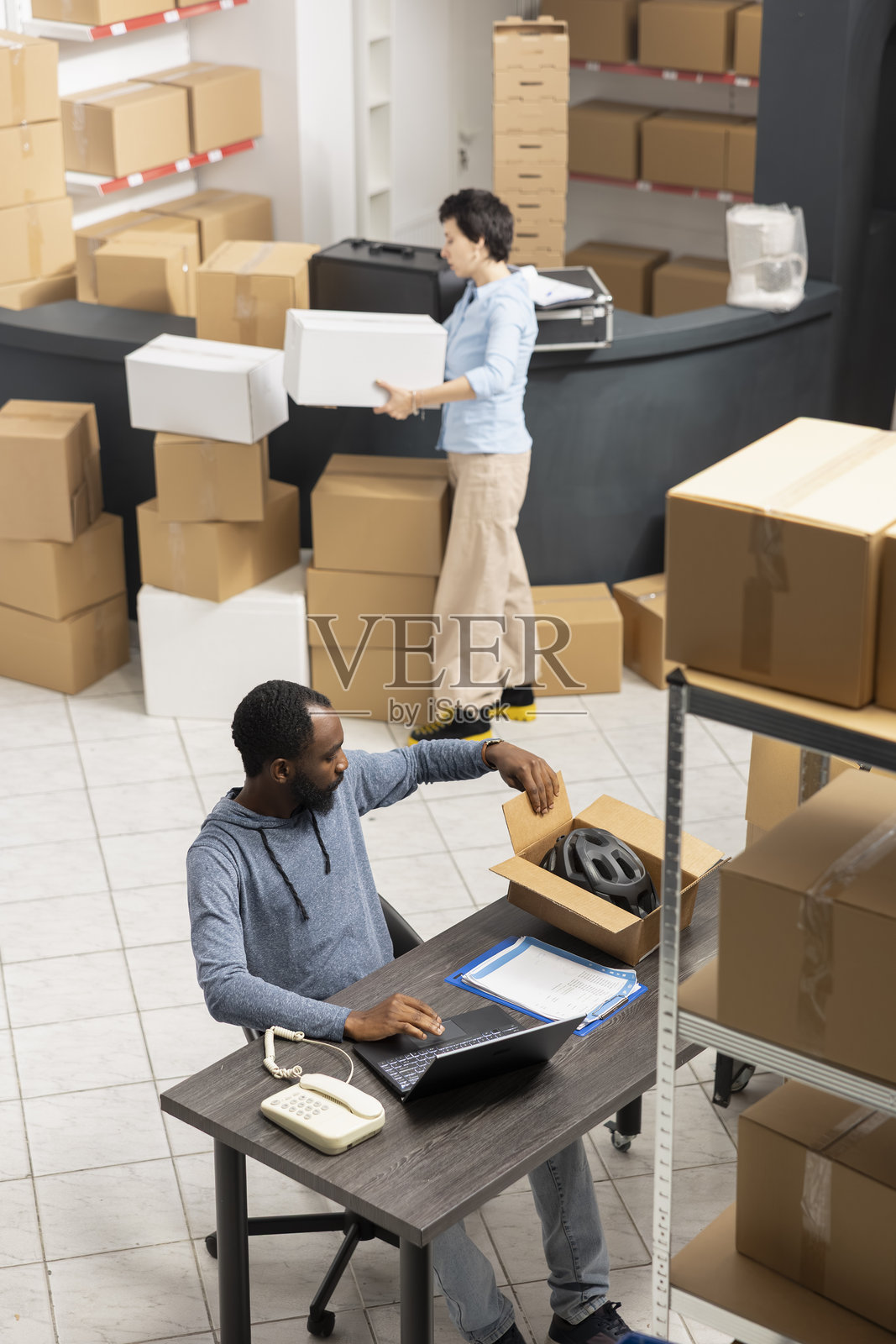 黑人男性员工在桌子前整理本地品牌的定制订单照片摄影图片