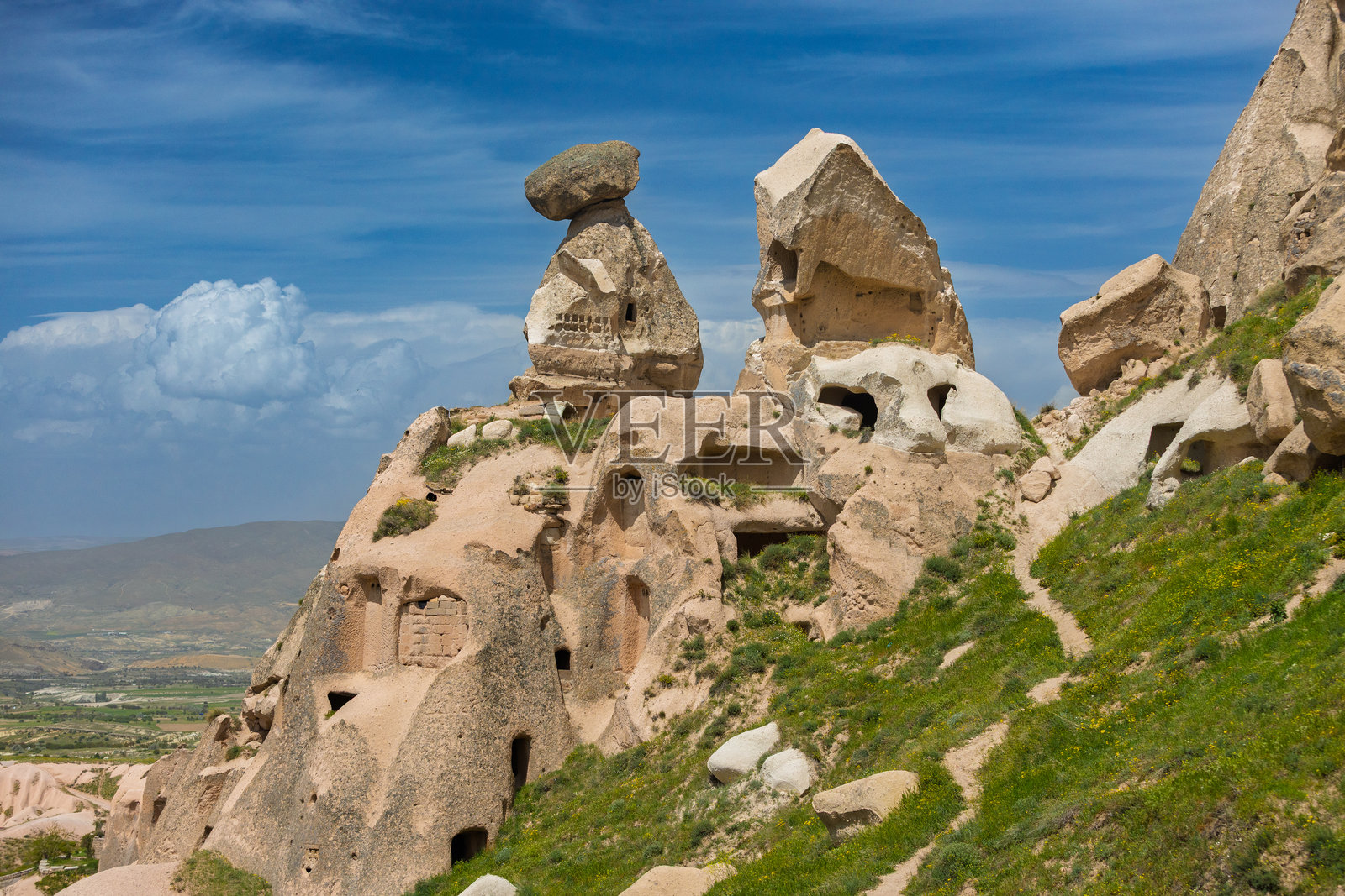 土耳其卡帕多奇亚乌奇希萨尔的沙锥间狭窄小径，洞穴房屋环绕。照片摄影图片