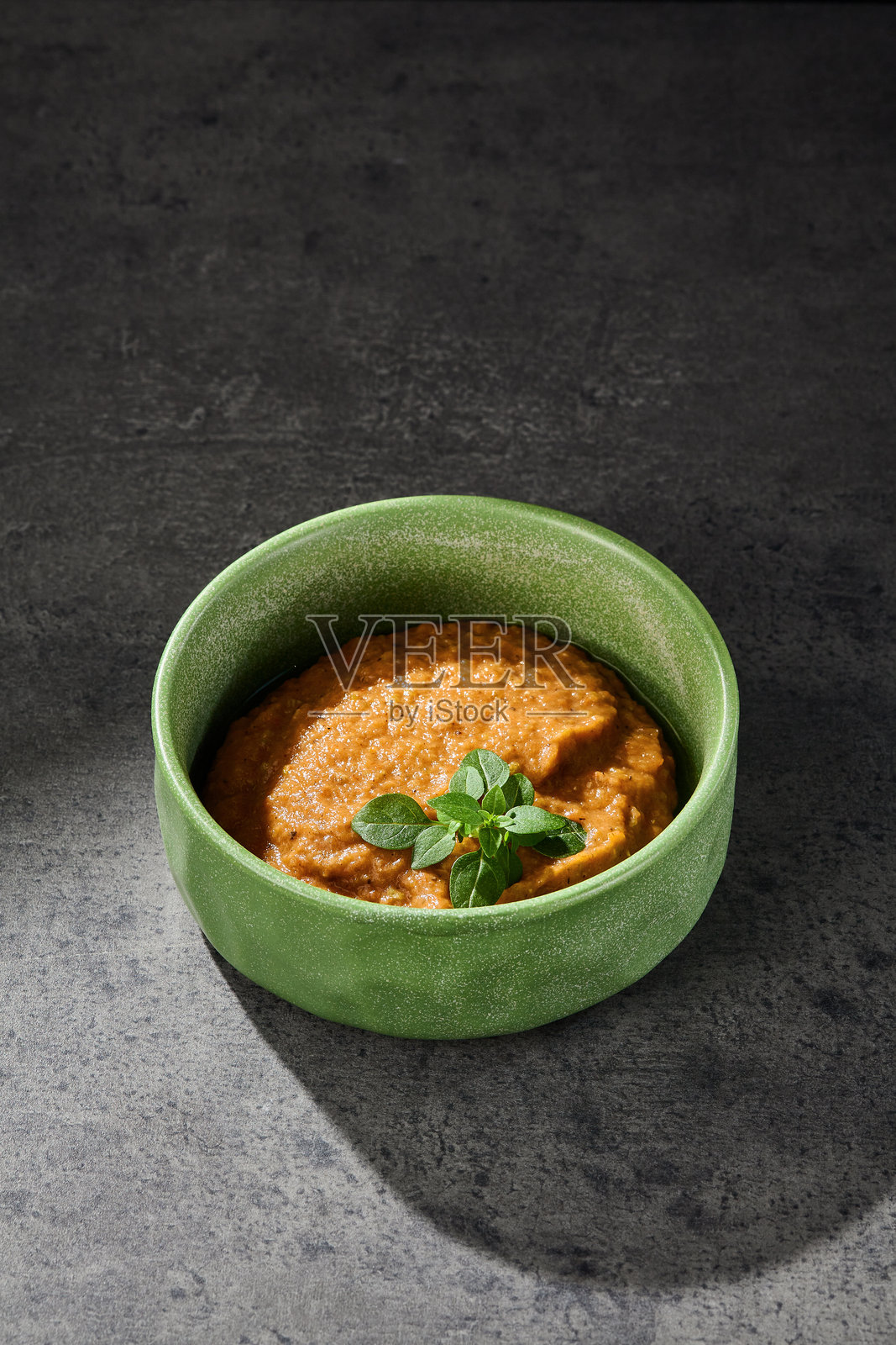 绿色陶瓷碗中的茄子鹰嘴豆泥，乡村风格的灯光，俯视构图照片摄影图片