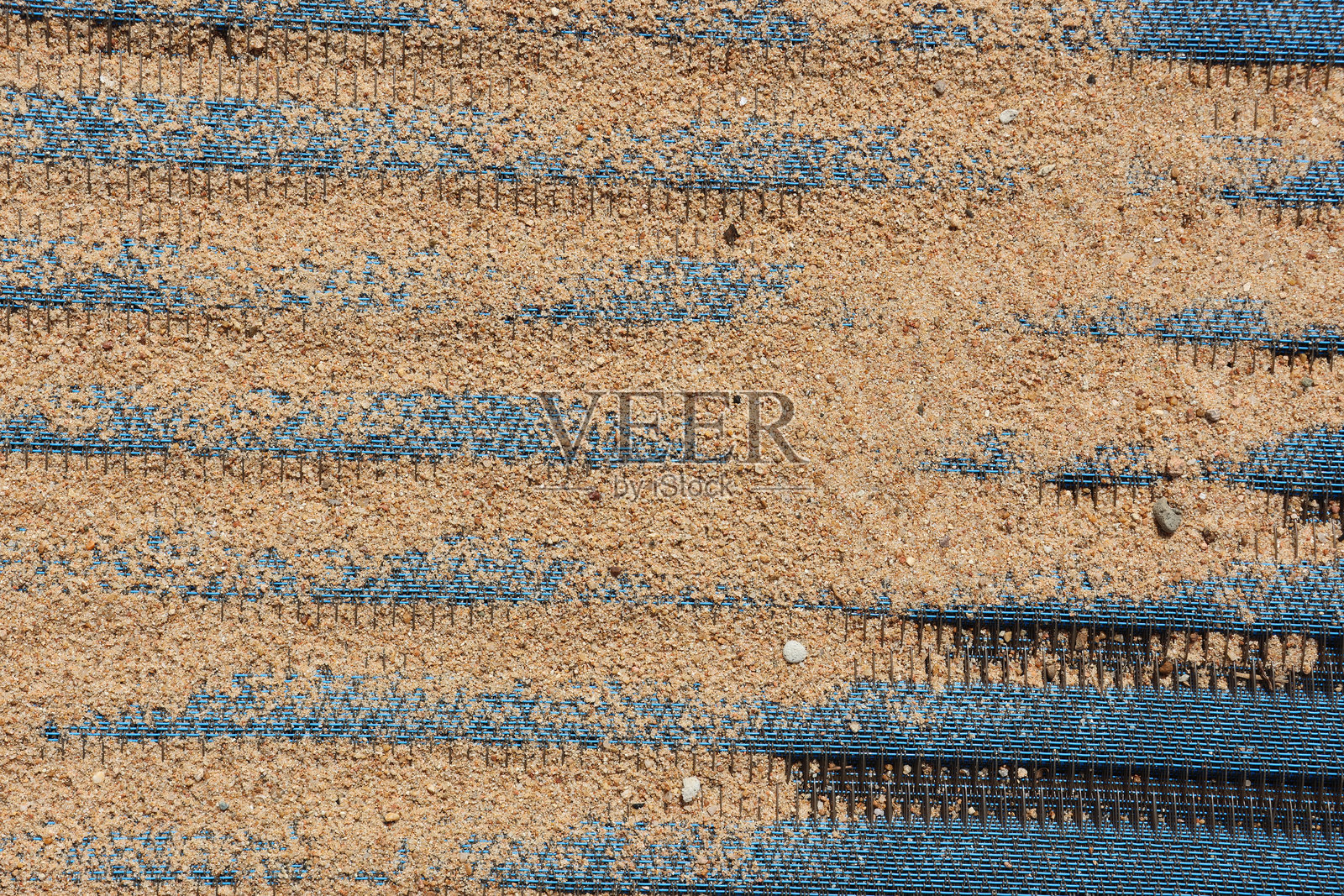 沙子覆盖在蓝色编织面料上，海滩特写纹理背景抽象照片摄影图片