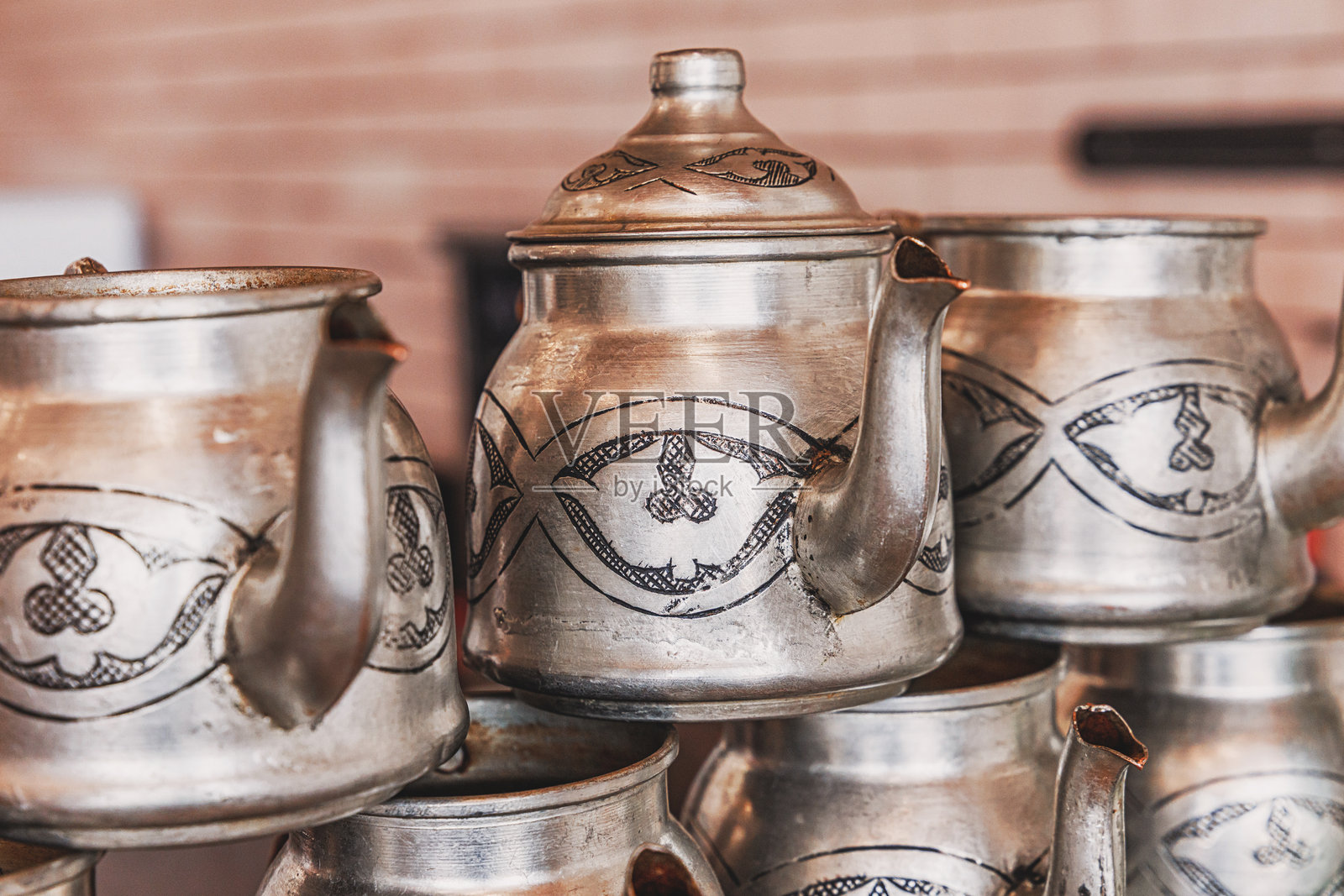 特写堆叠的雕刻金属茶壶，突显传统工艺和文化遗产照片摄影图片