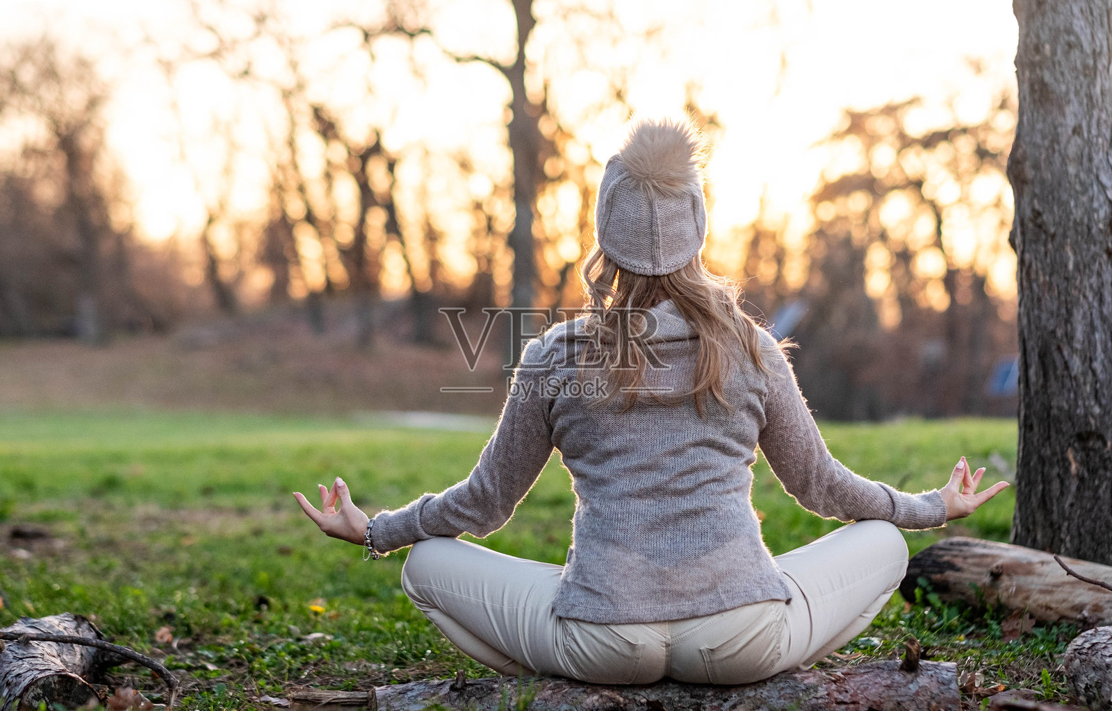 在日落时分，女性在大自然中冥想，寻找内心的平静与专注。照片摄影图片