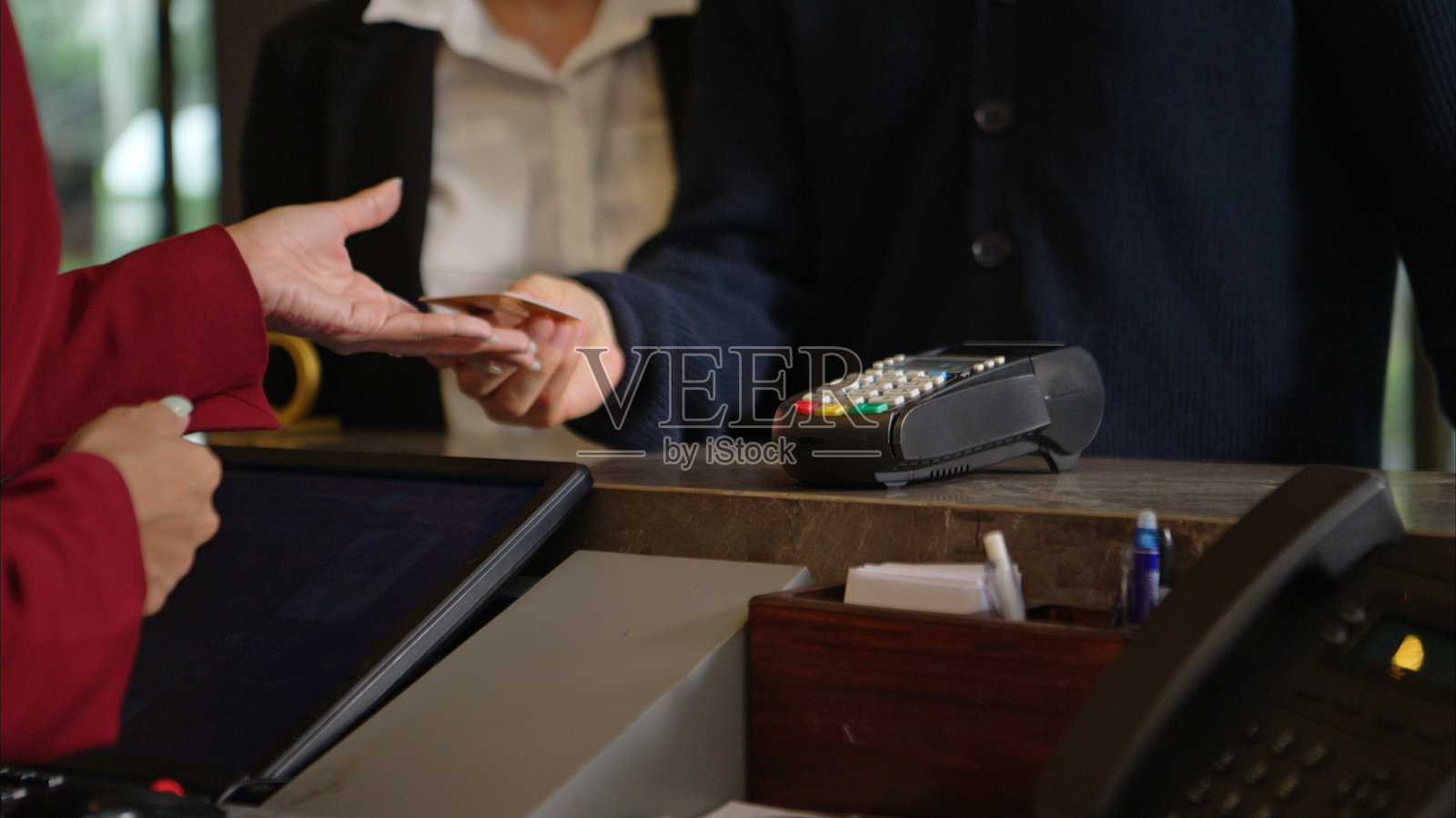 顾客在酒店前台使用信用卡终端付款照片摄影图片