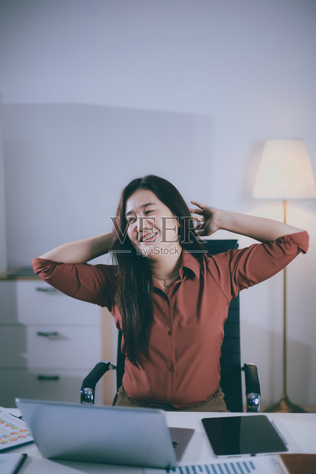 迷人的亚洲女商人在长时间坐着工作后放松，以避免办公室综合症。照片摄影图片