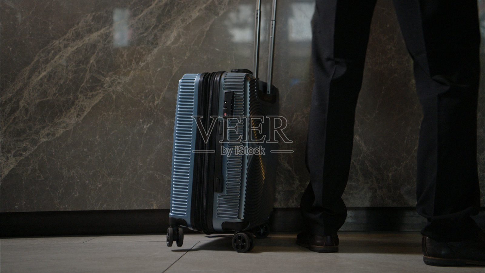 在酒店大堂站着的旅客，行李箱放在轮子上，准备办理入住手续照片摄影图片