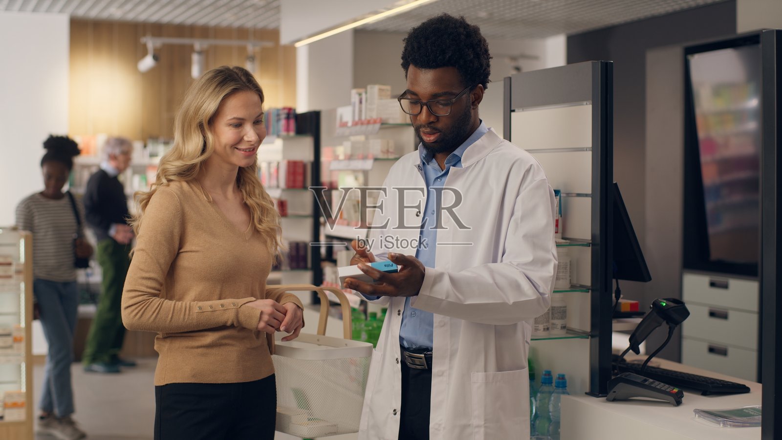非裔美国男性药剂师为顾客咨询医疗处方，白人女性在药店购买药物，医生和患者提供帮助，药品健康护理，订购药丸、药物和维生素。照片摄影图片