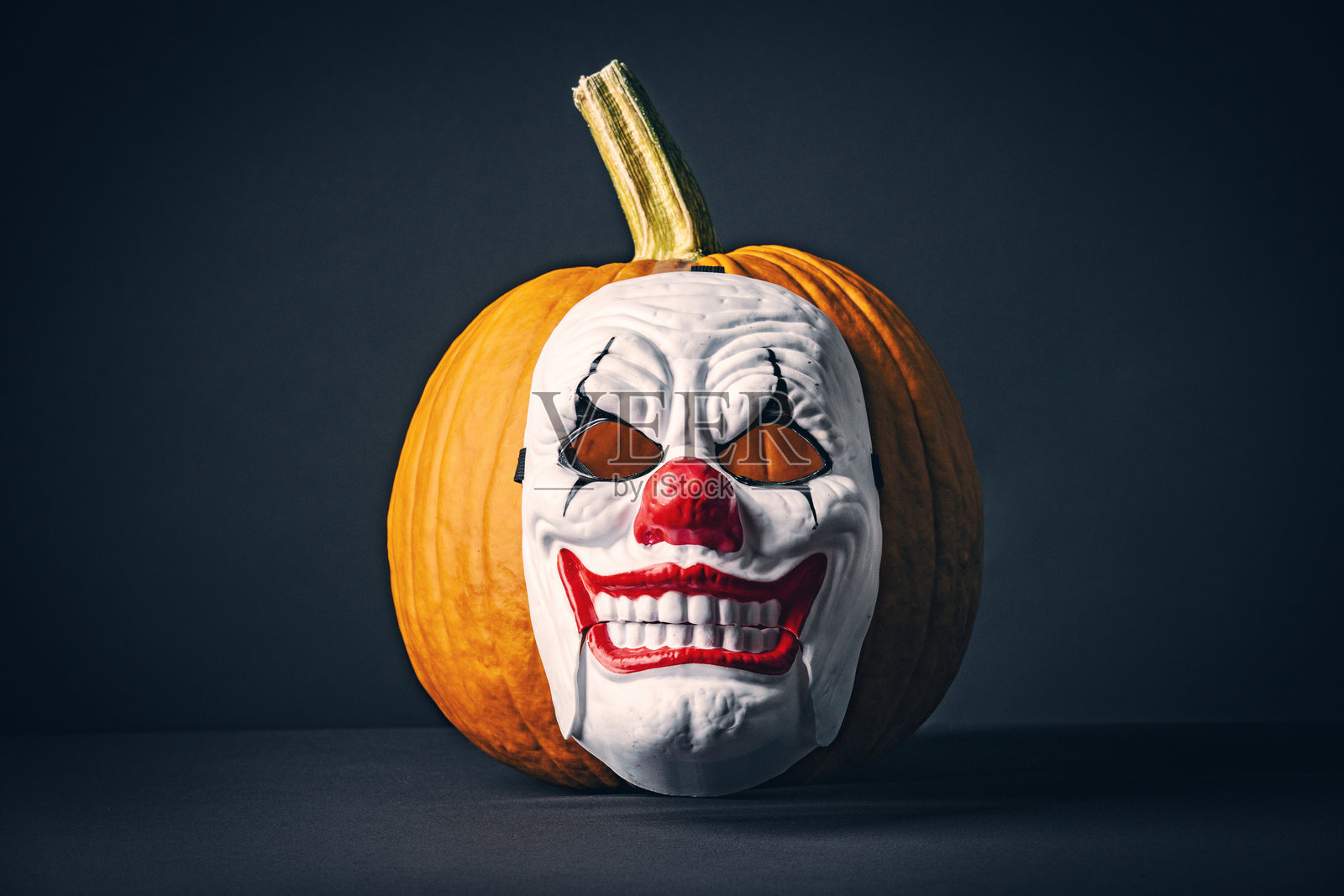 戴着小丑面具的万圣节南瓜照片摄影图片