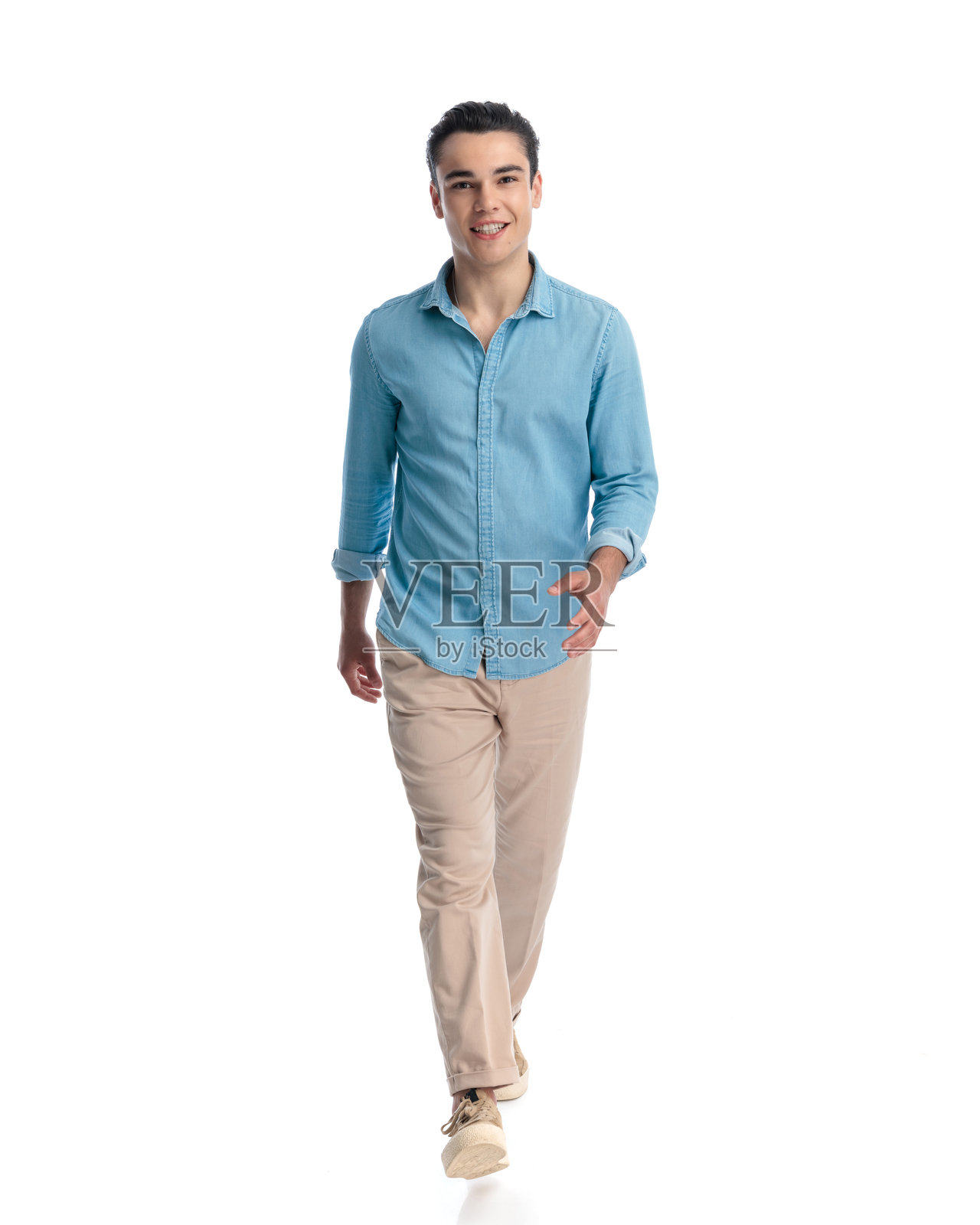 穿着蓝色牛仔衬衫的快乐休闲男士走路并微笑照片摄影图片