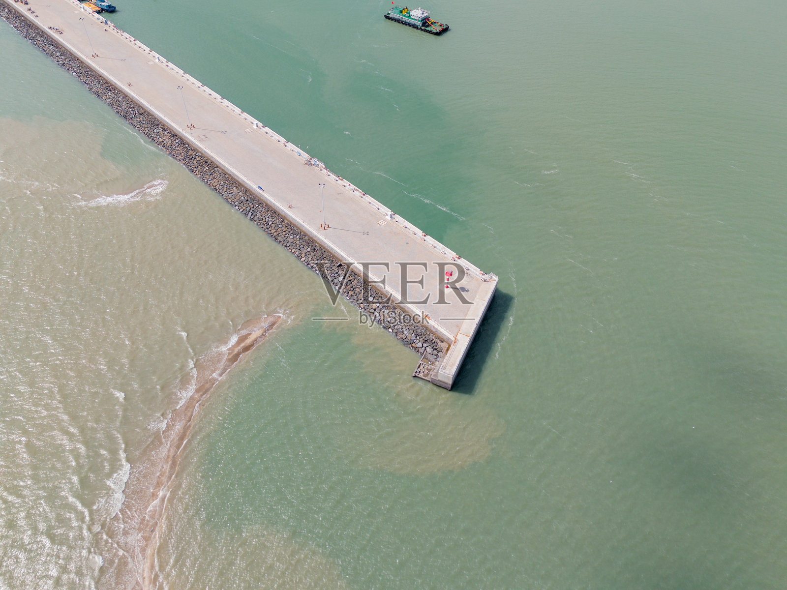 海堤的鸟瞰图：碧蓝海水与防波堤结构的壮丽交汇照片摄影图片