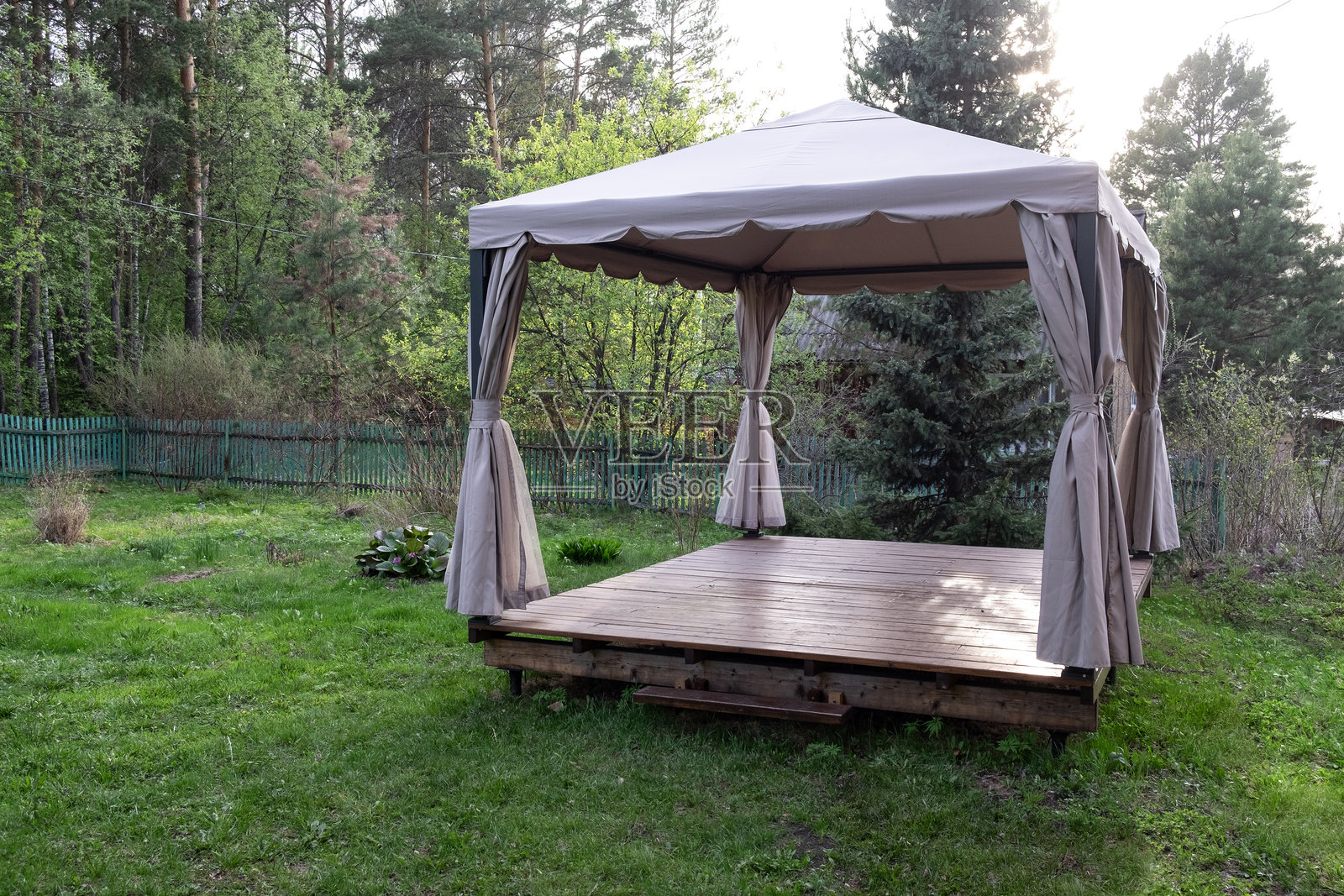 优雅的布艺凉亭，配有帷幕，位于花园的自然环境中照片摄影图片