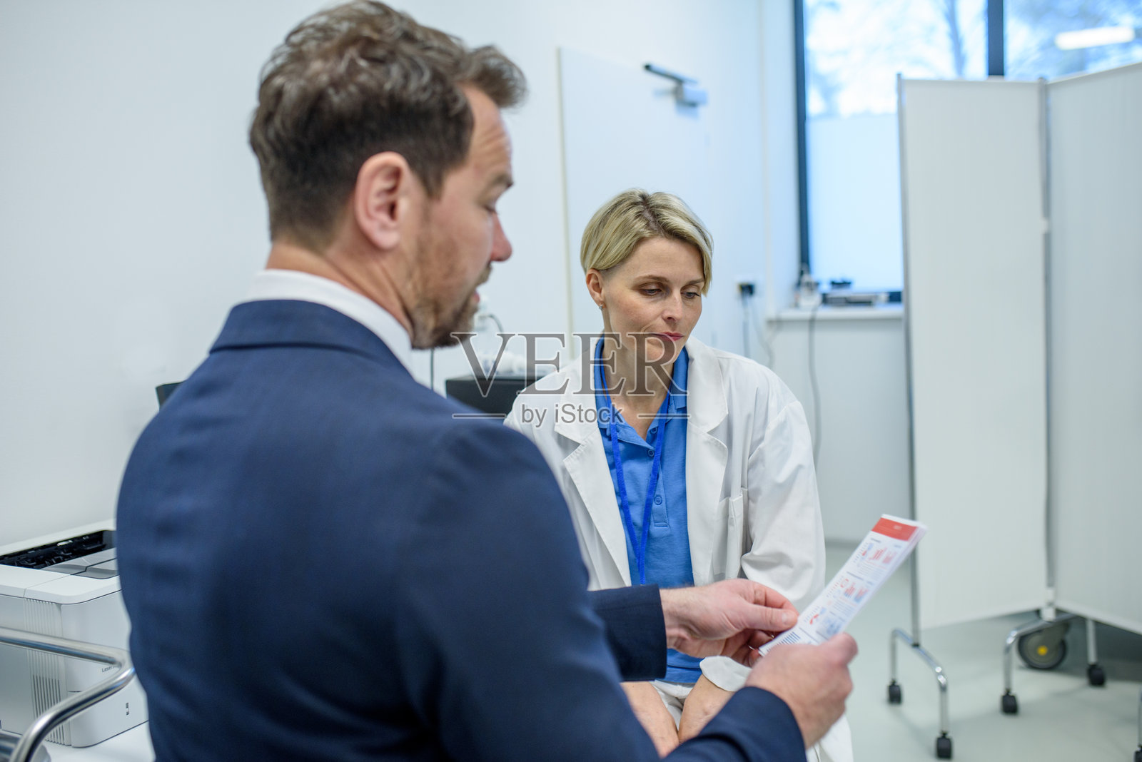 药品销售代表向女医生介绍新药。照片摄影图片