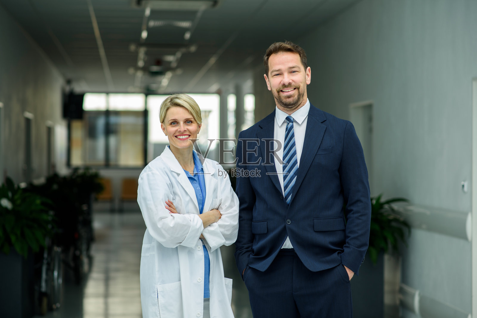 男性医院经理站在女性医生旁边，医疗环境。照片摄影图片