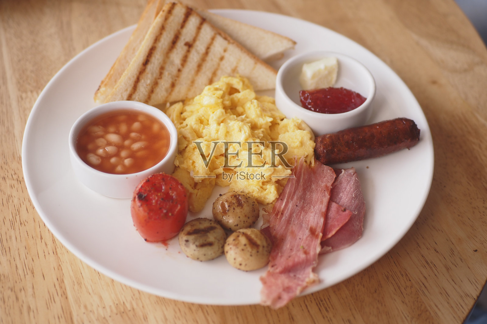 美味的早餐盘，包含鸡蛋、吐司和豆子，在咖啡馆中供应照片摄影图片