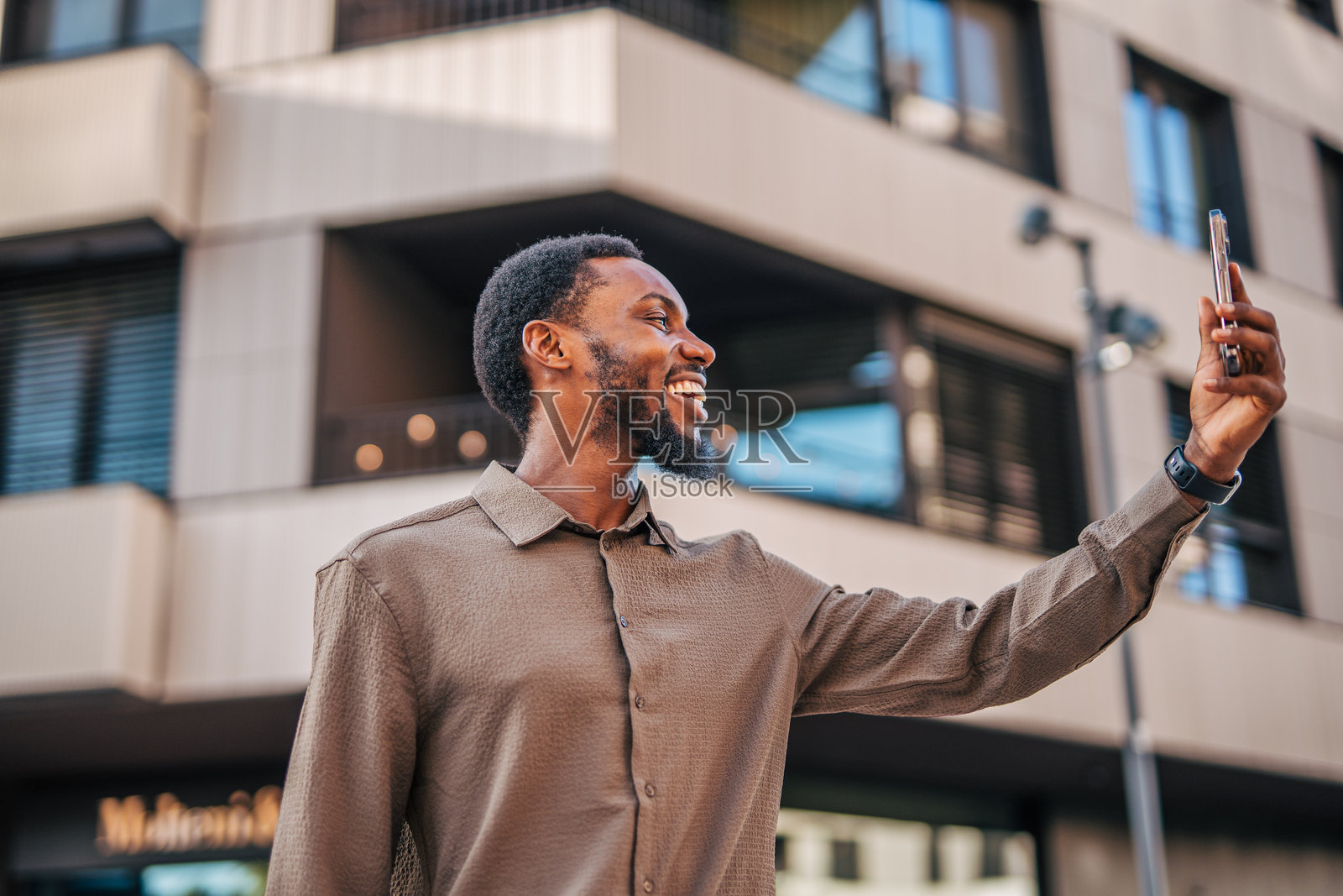 年轻商人在市中心用智能手机自拍照片摄影图片