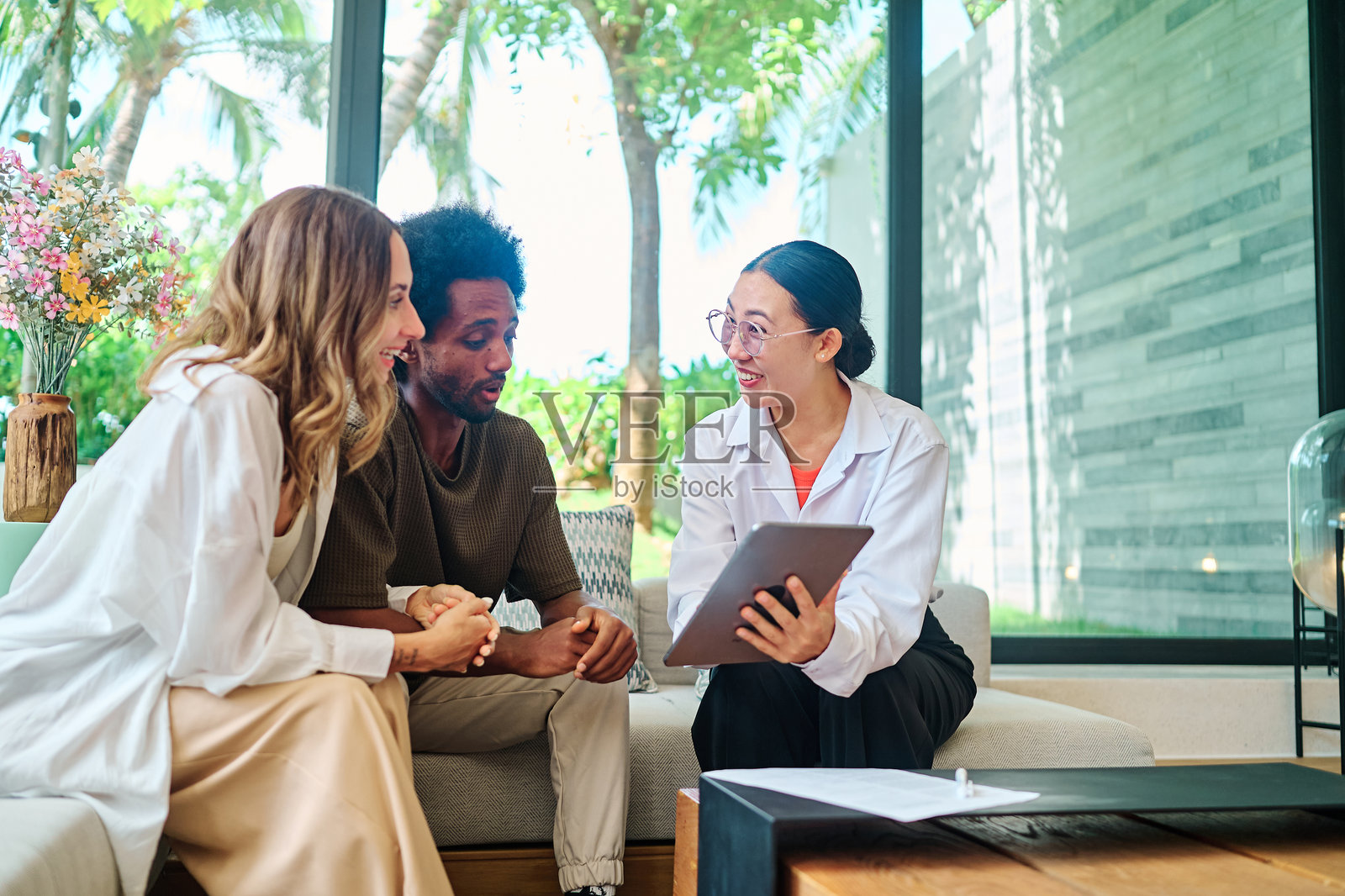 年轻夫妇与房地产经纪人会面，讨论保险投资和财务建议，签署商业合同。照片摄影图片