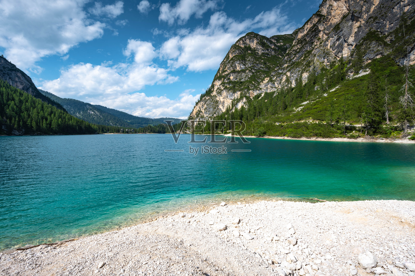 下午，在白云石山脉的绿松石山湖的石质海滩上，景色优美。布雷斯湖(Pragser Wildsee, Lago di Braies)，白云石，南蒂罗尔，意大利，欧洲。照片摄影图片