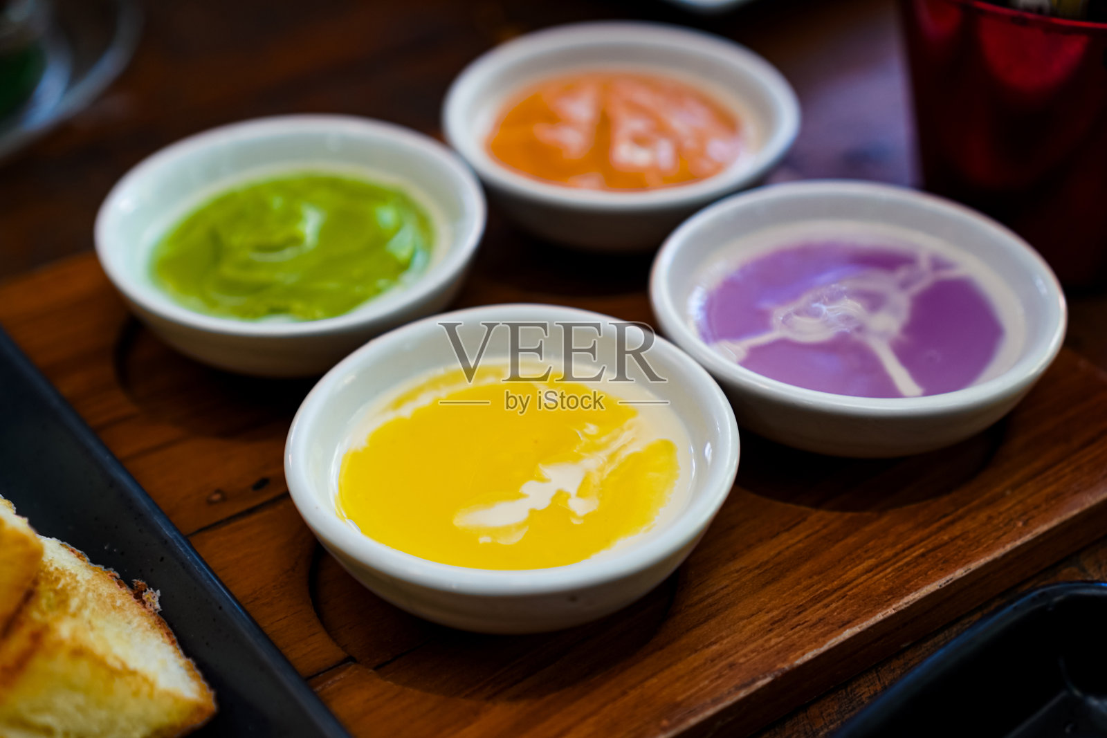 五彩缤纷的泰式布丁蘸酱盛在小碗中照片摄影图片