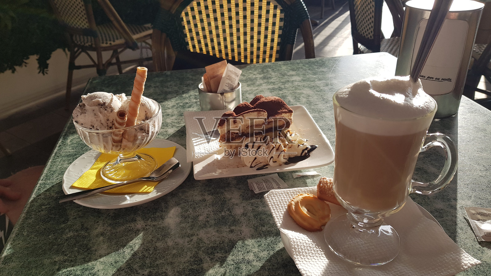 在阳光下吃冰淇淋，拿铁和糖果照片摄影图片