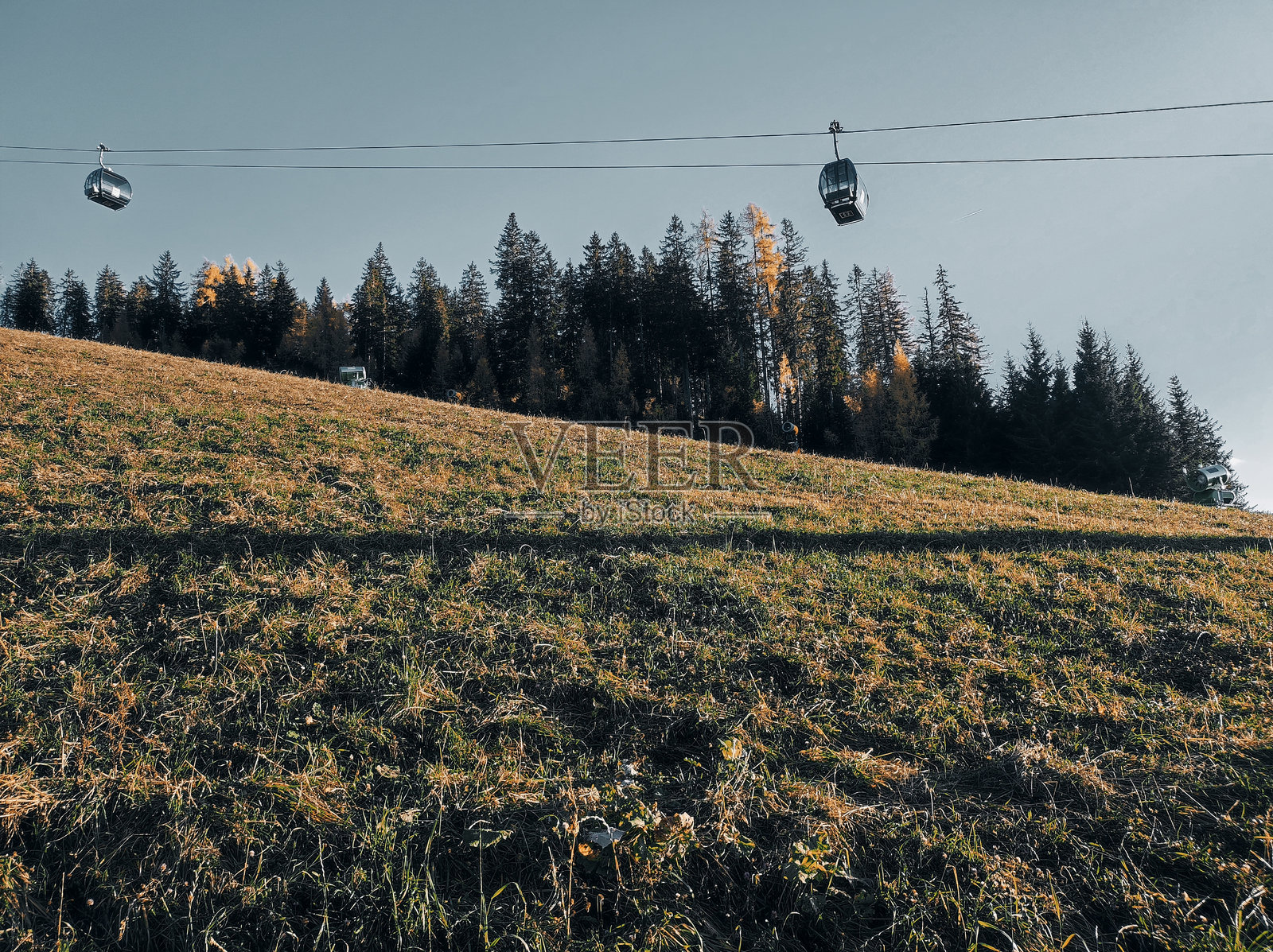 缆车在秋季山景中穿行，傍晚时分。照片摄影图片