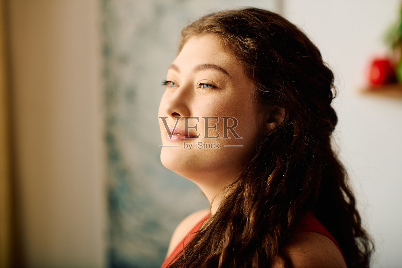 在一个阳光明媚的下午，一位卷发的年轻女子在家里享受着安静的时光照片摄影图片