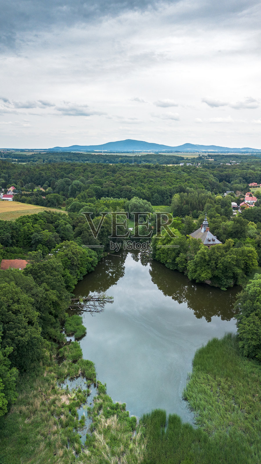 傍晚，苍翠的森林环绕着宁静的湖泊鸟瞰图照片摄影图片