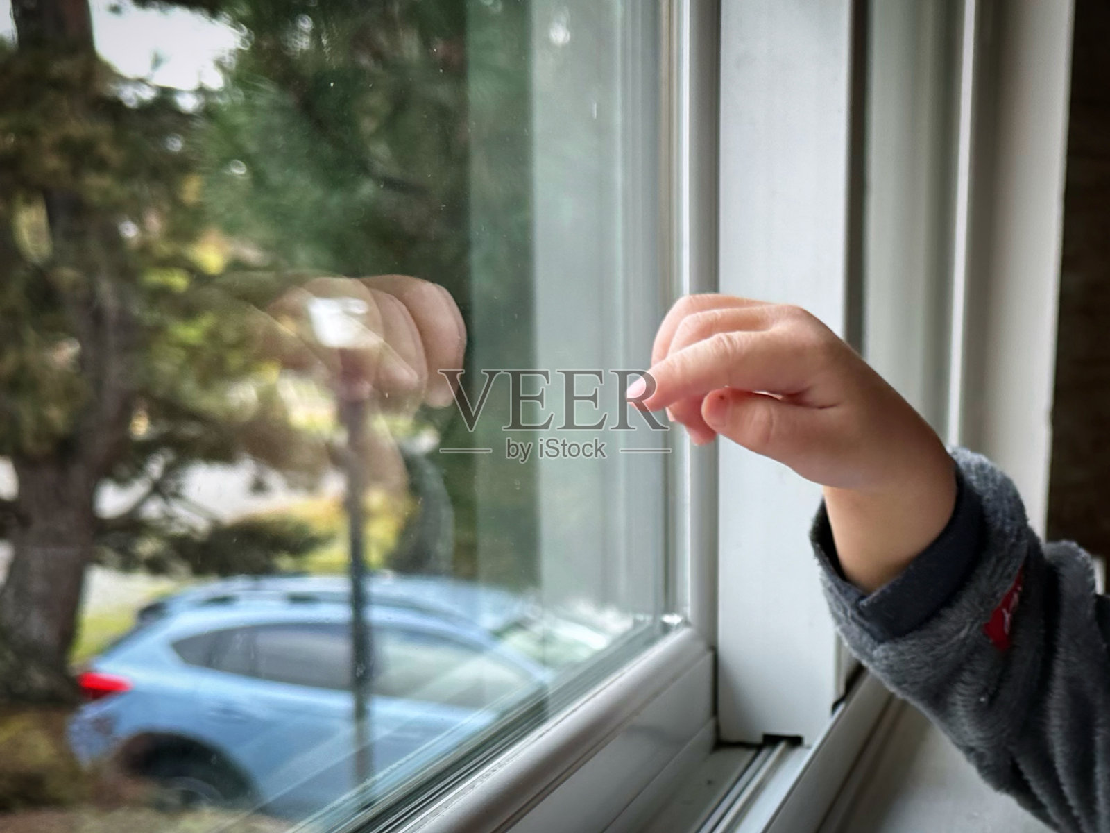 一个孩子伸手去摸窗户照片摄影图片