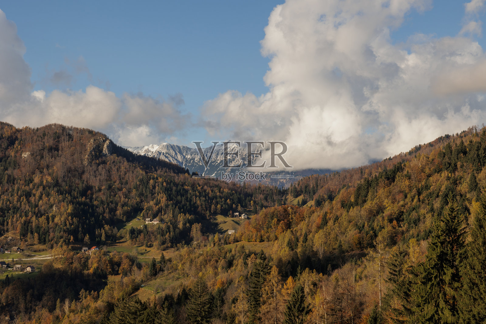 在秋天，斯洛文尼亚的自然环境被午后的阳光照亮。白色积云在远山上空移动照片摄影图片