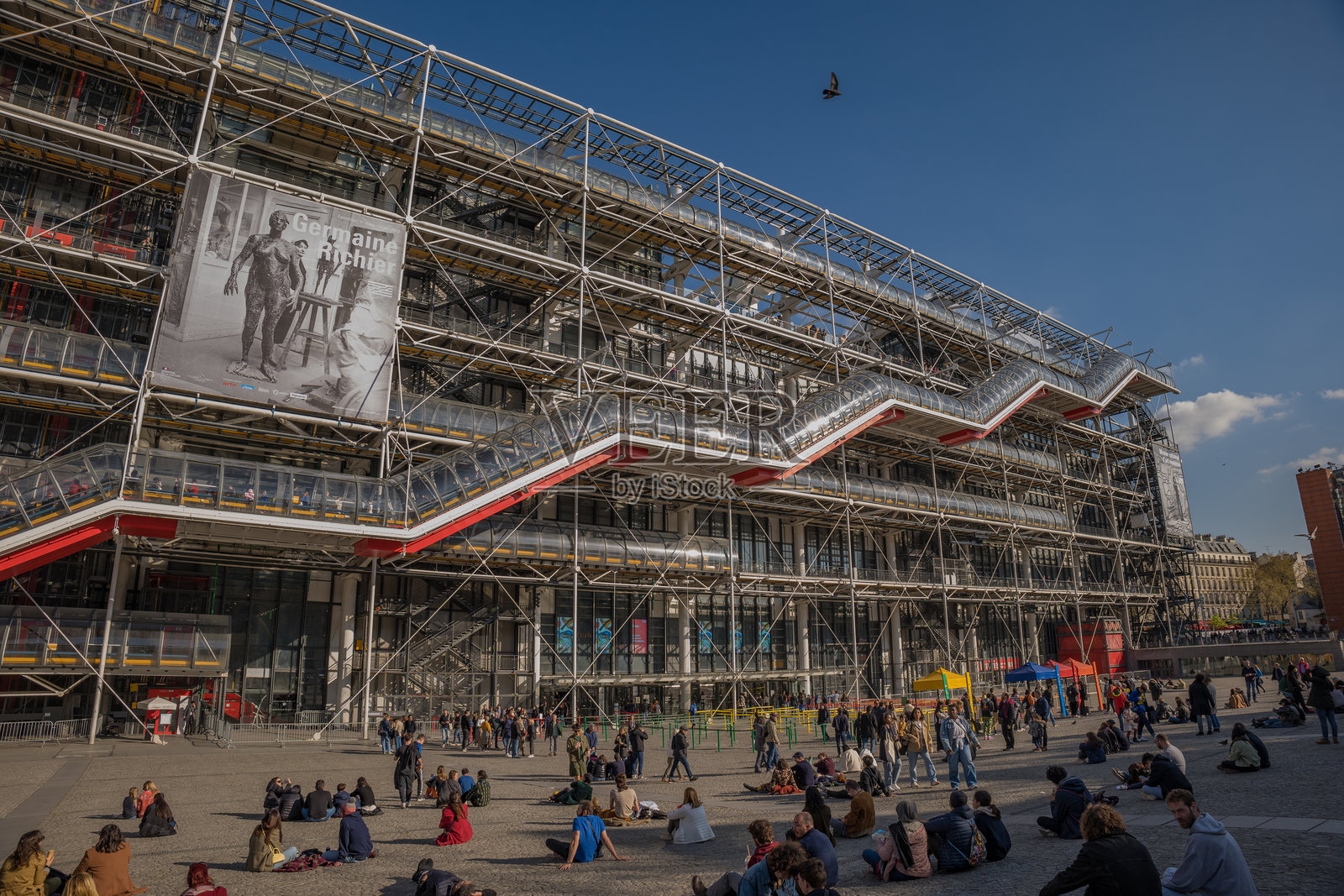 巴黎蓬皮杜中心 - 人群在下午的阳光下悠闲地在庭院中放松照片摄影图片