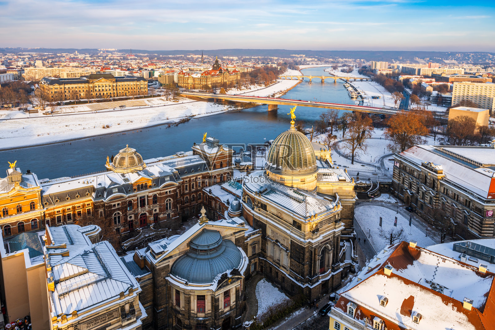 在一个寒冷的冬日傍晚，德累斯顿和易北河的城市景观被大雪覆盖。照片摄影图片