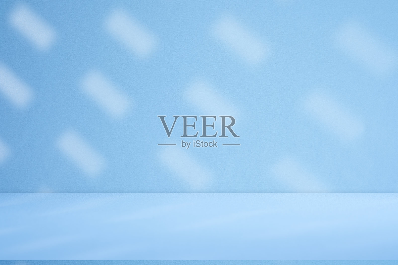 工作室风格的背景墙装饰呈现采用白色和蓝色调。阴影从附近的窗户投射出来，创造了一个装饰性的概念照片摄影图片