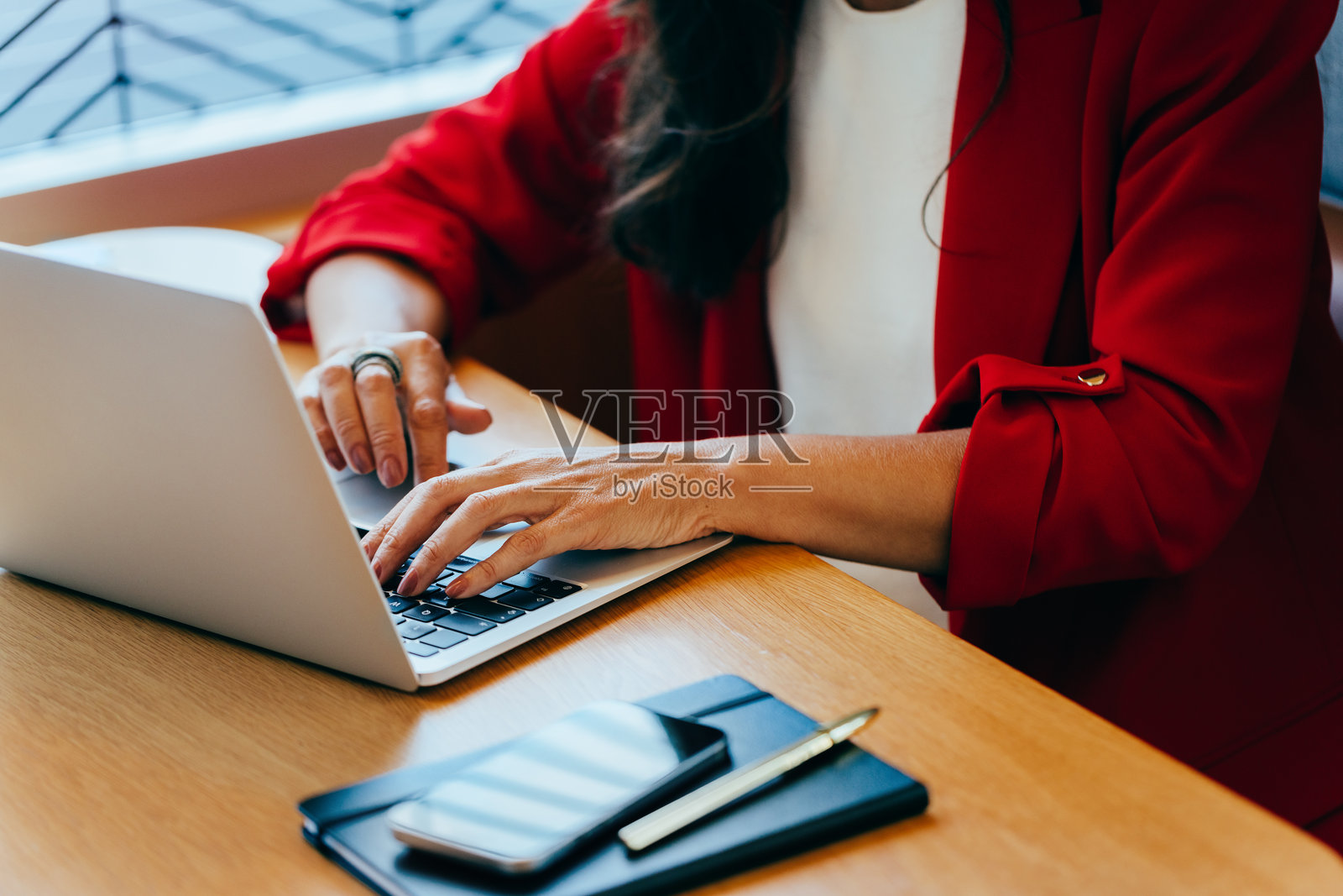 专业人士在木桌上使用笔记本电脑打字。照片摄影图片