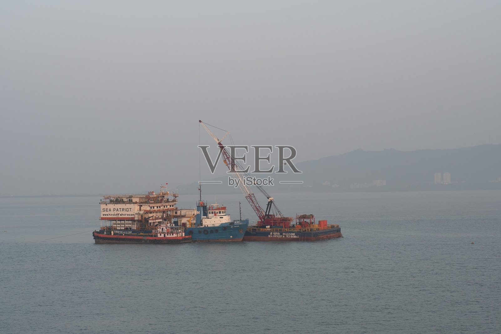 拖船、浮吊和货物驳船在海上区域的联合运输作业照片摄影图片