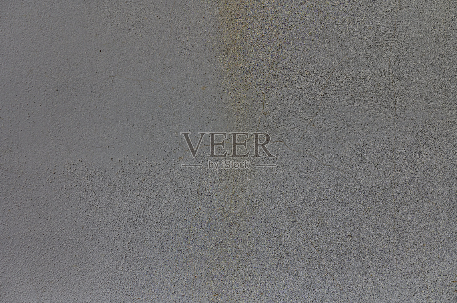 在黄昏柔和的光线下，探索一面风化的灰泥墙上的纹理和阴影，色调柔和而低调。照片摄影图片