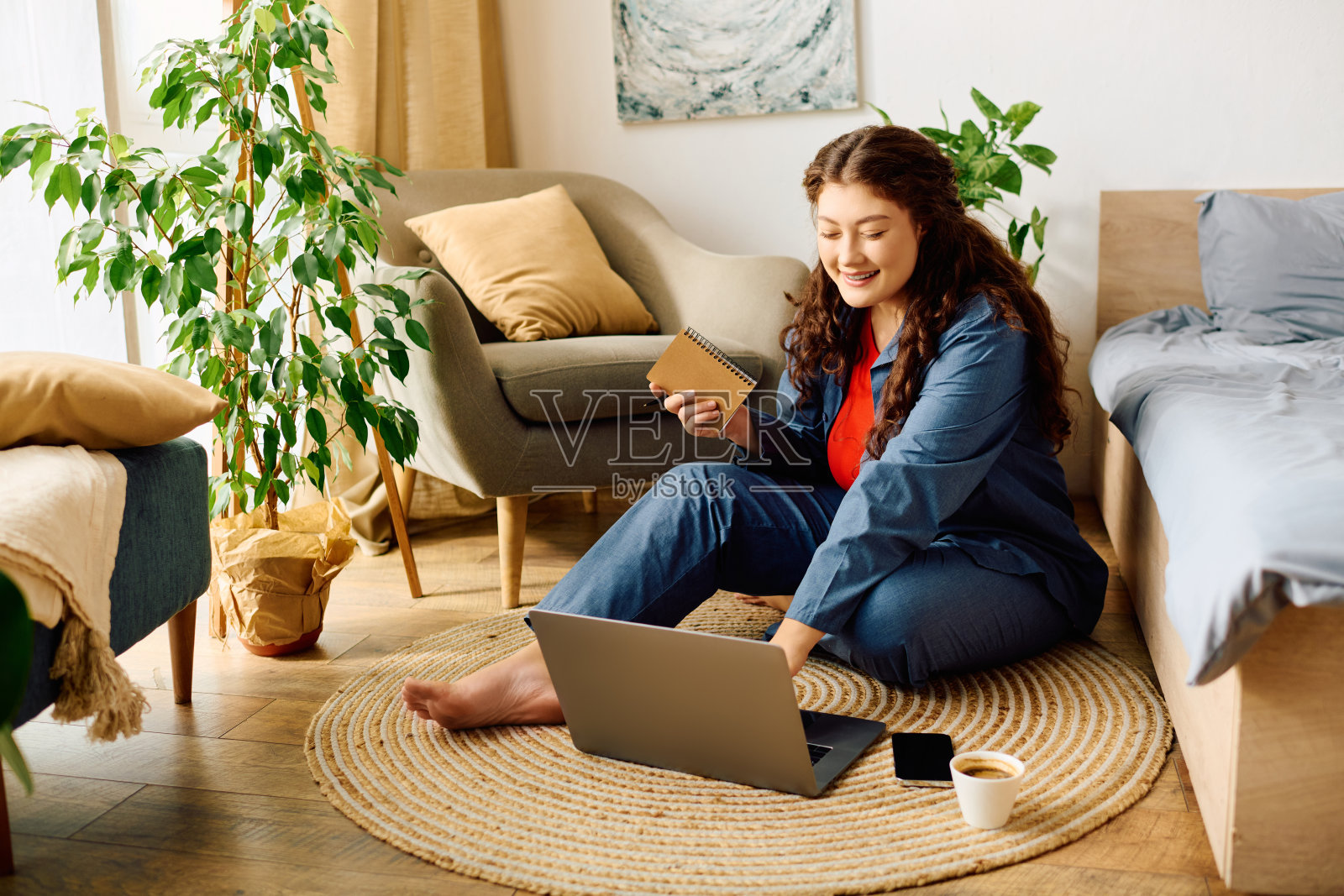 一个大码卷发的年轻女人享受着在笔记本电脑上工作的惬意下午照片摄影图片