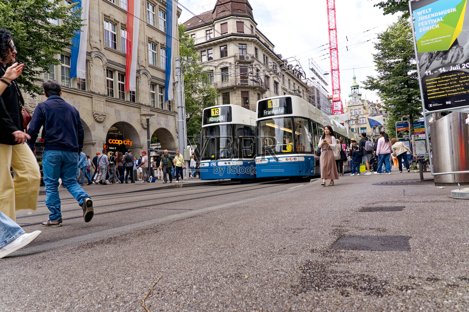 瑞士z<e:1>里奇市著名的购物街Bahnhofstrasse，夏天的一天，电车站挤满了人。照片摄影图片