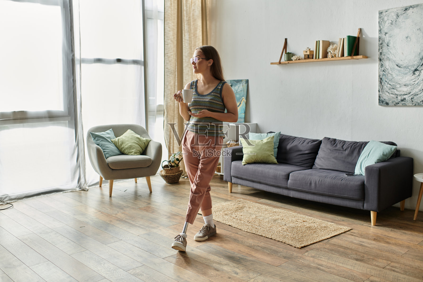 戴着假腿的年轻女子在午后的阳光下享受着她时髦的客厅照片摄影图片
