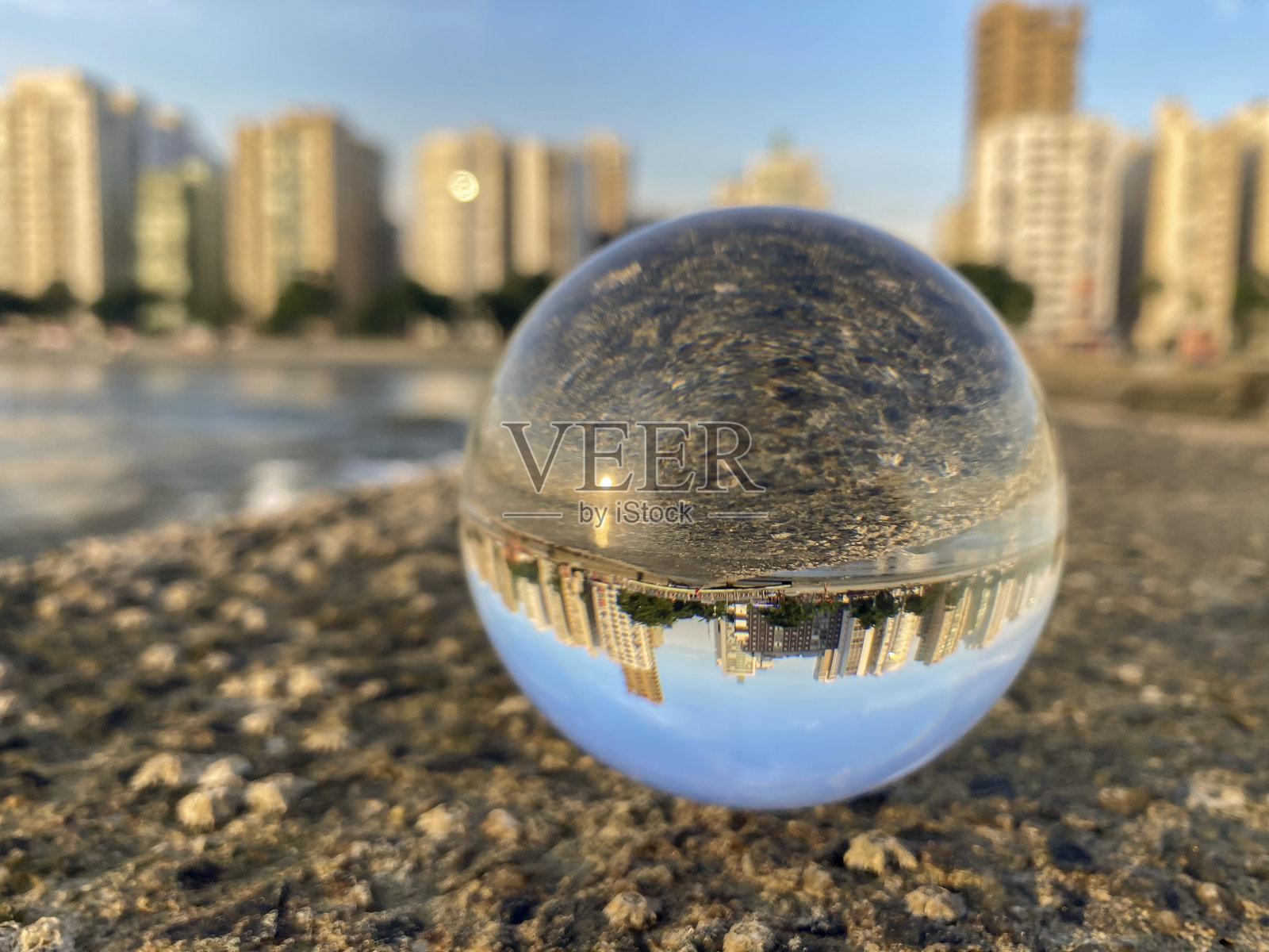 这个玻璃球的焦点反映了巴西桑托斯市海滩上的建筑。照片摄影图片