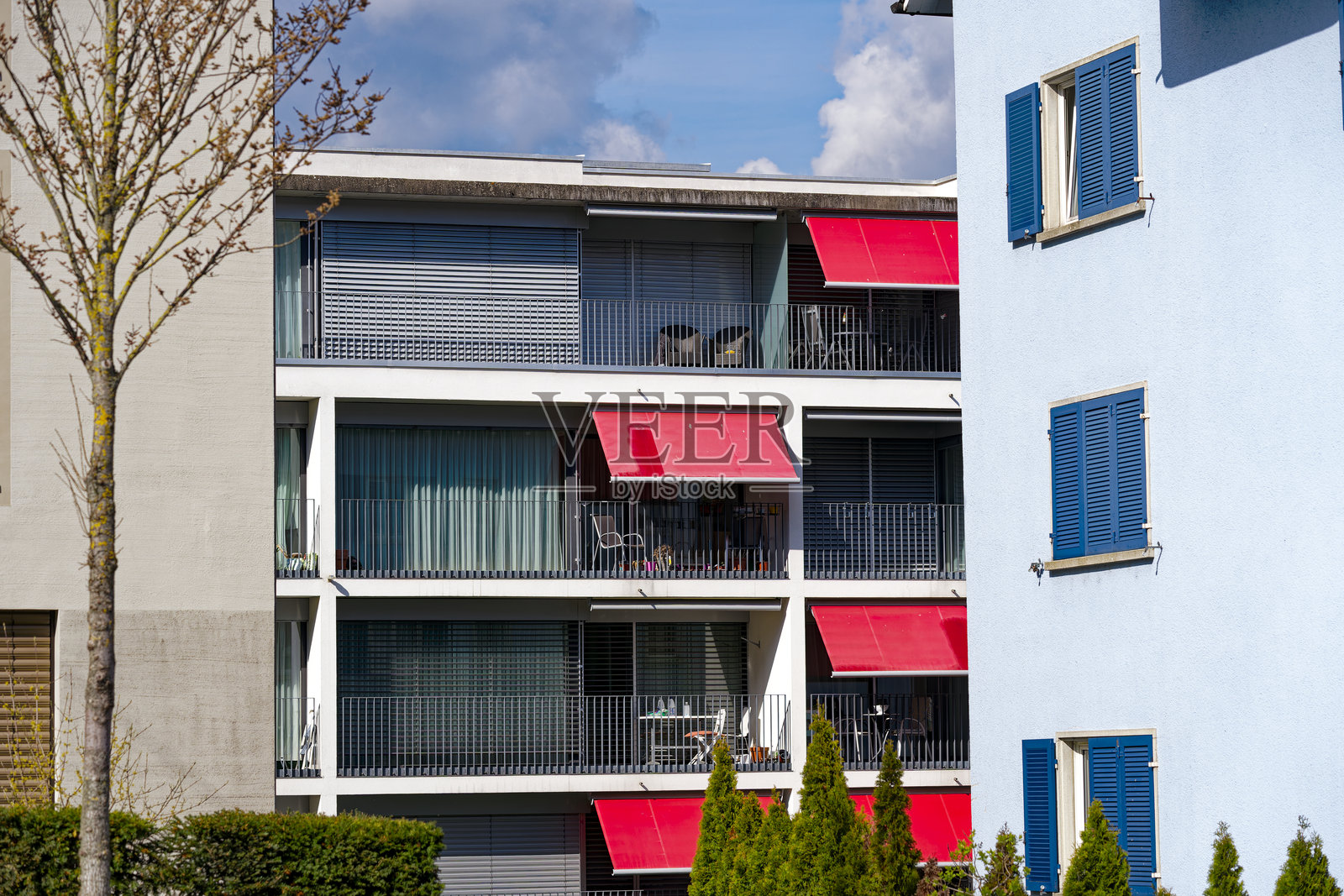 瑞士小镇的阳台正面,有椅子、桌子和花盆。照片摄影图片