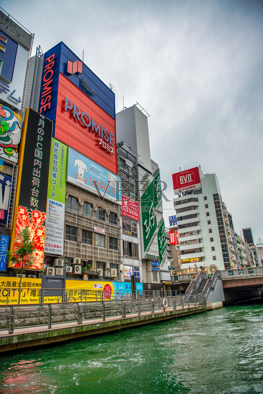 多云的下午，道顿堀江边的道顿堀大厦。照片摄影图片