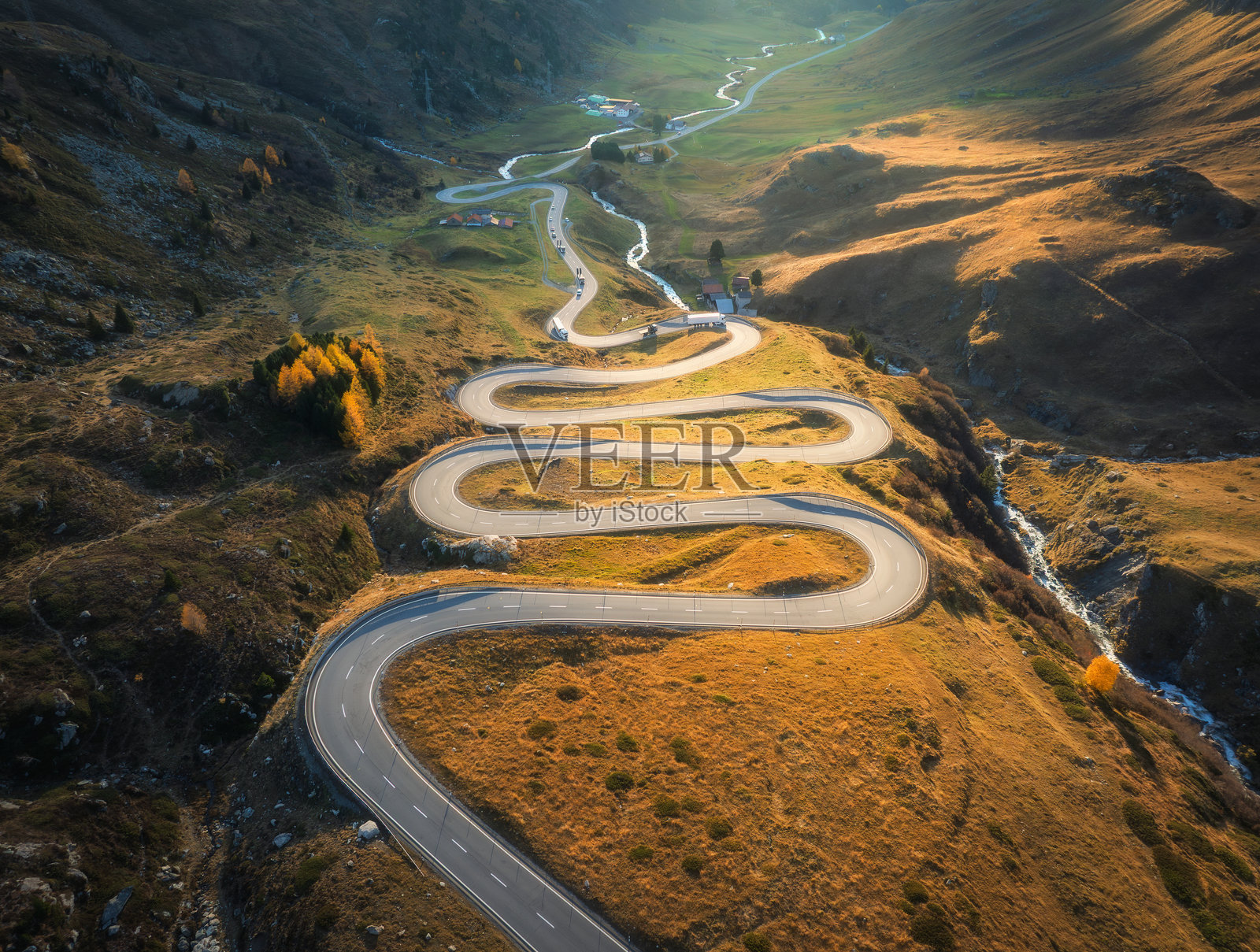 蜿蜒山路的鸟瞰图，阿尔卑斯山谷中的河流照片摄影图片