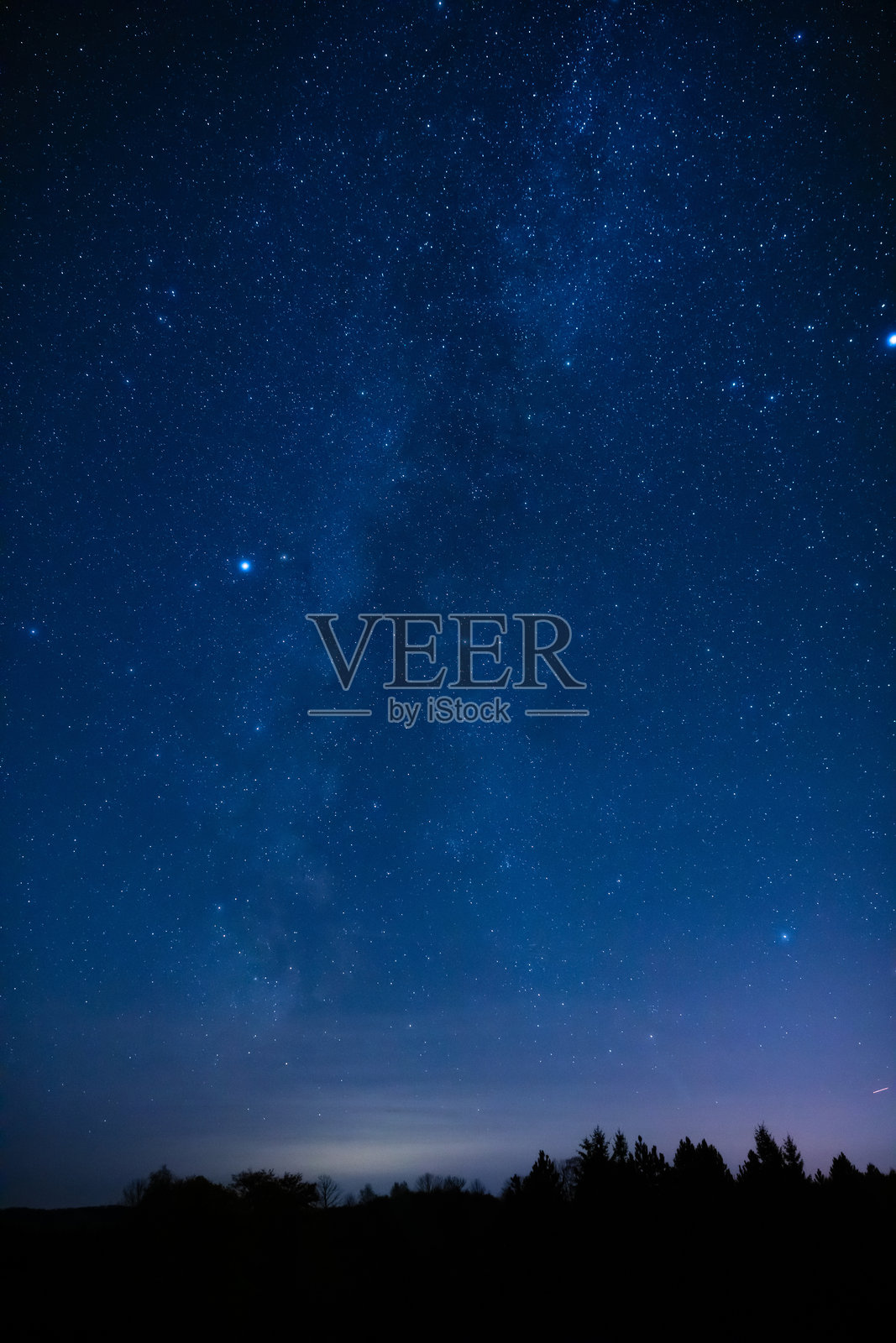 银河系的星星与乡村树木和风景的剪影。照片摄影图片