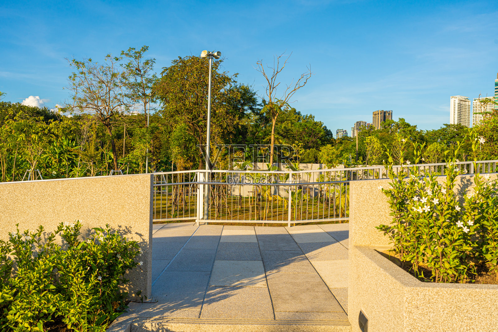 绿城公共公园中的步行小道，办公大楼与日落天空和云彩照片摄影图片