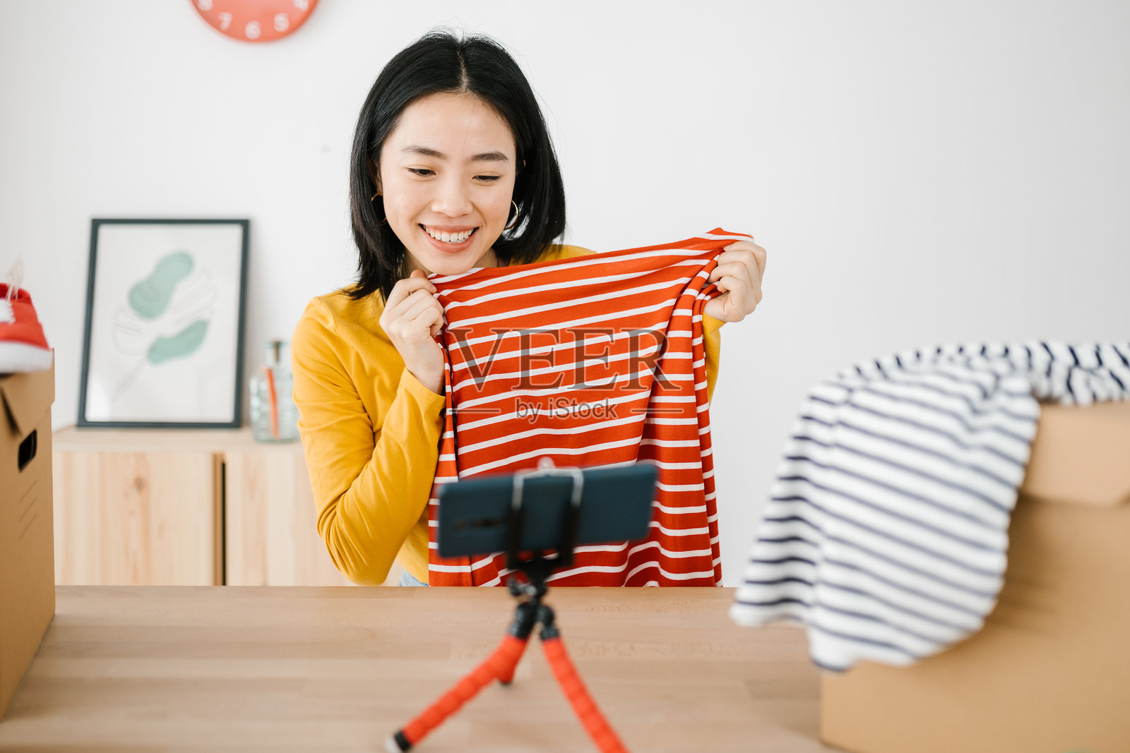 年轻的亚洲女性博主在线直播展示新衣服照片摄影图片
