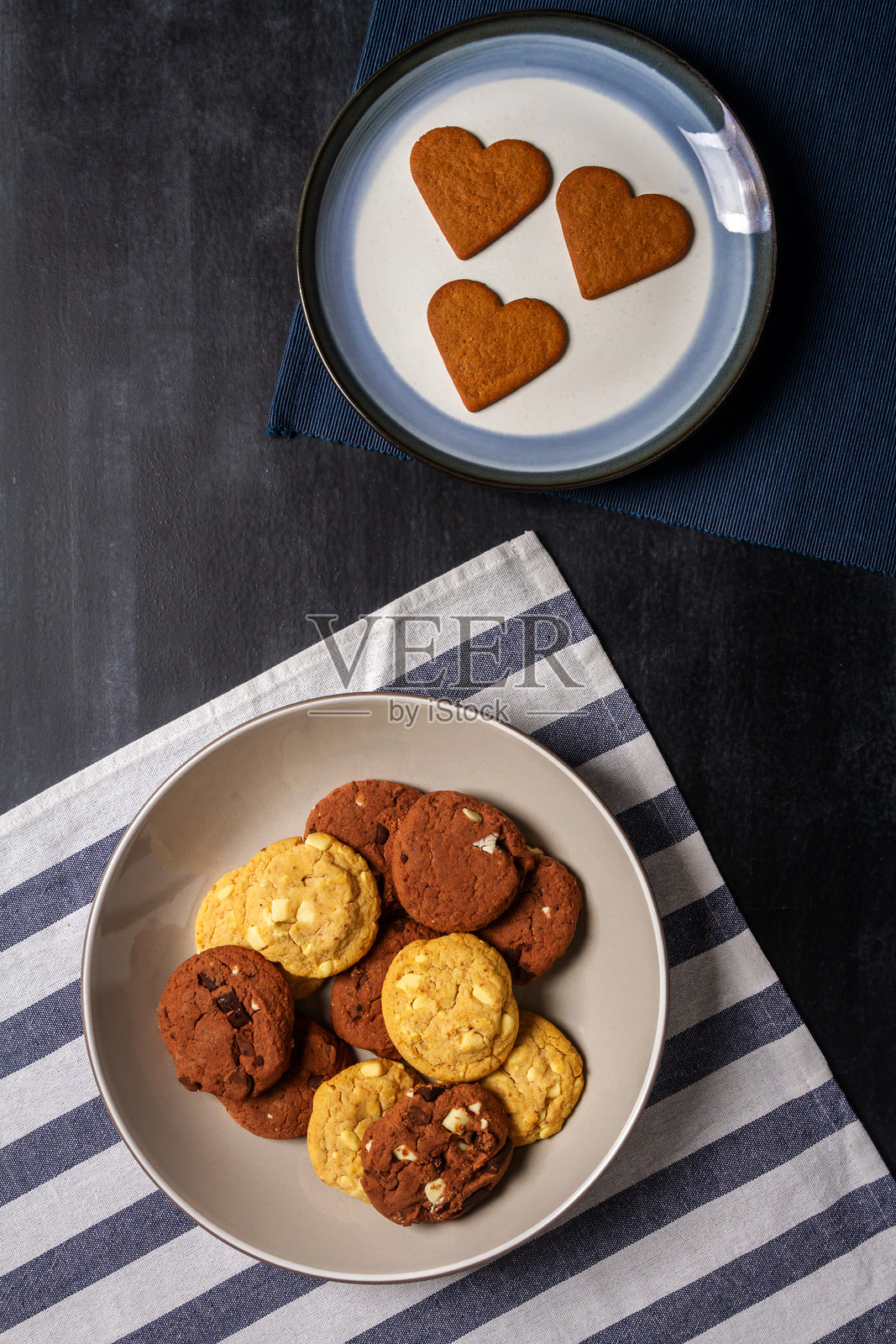 黑色黑板上的碗里放着一些饼干，空盘子和几块桌布照片摄影图片