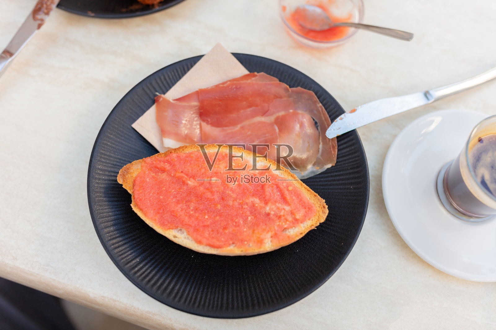 传统西班牙早餐，配有火腿、面包、西红柿和咖啡。西班牙，科尼尔德拉弗龙特拉，2025年9月6日。照片摄影图片