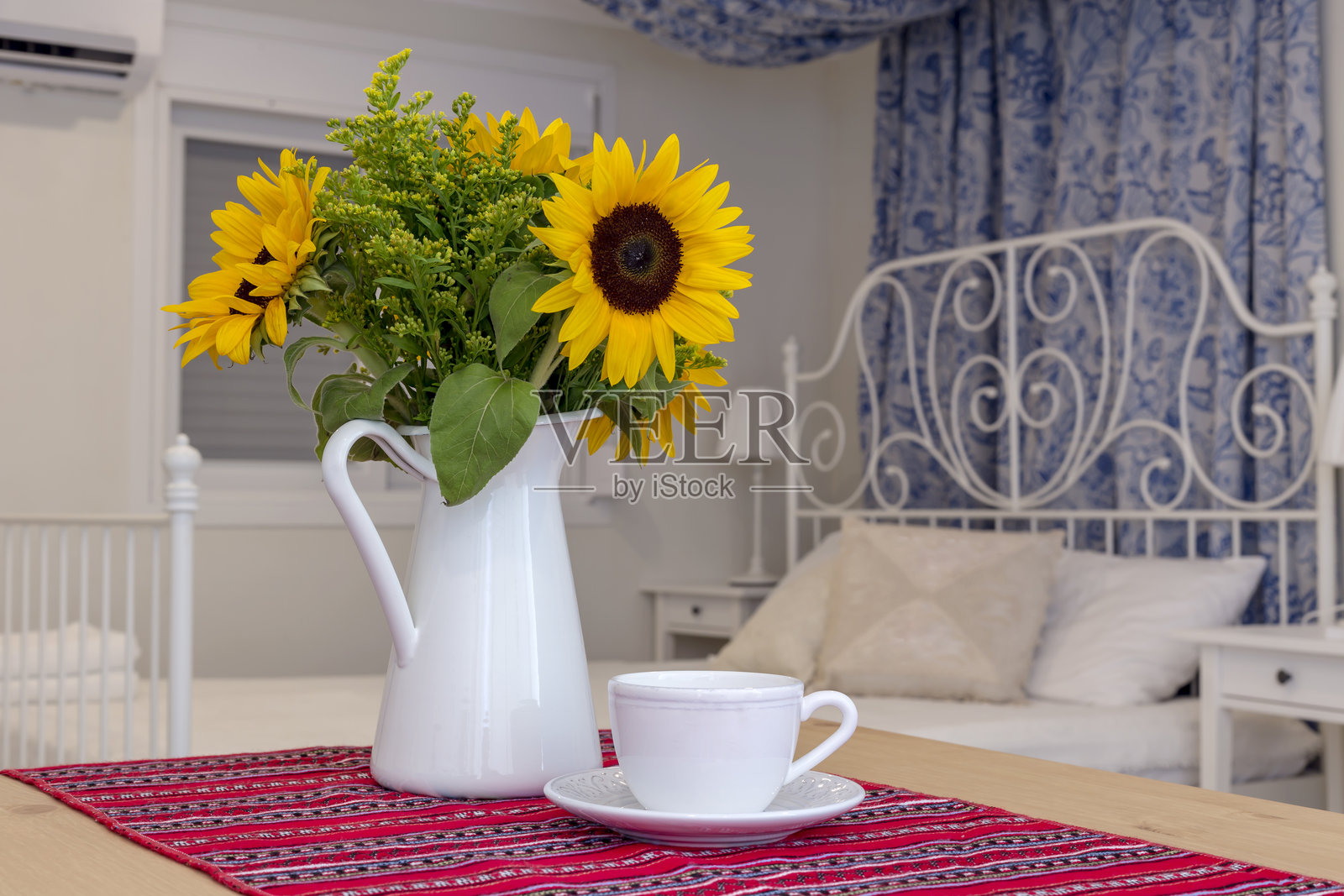 静物画：花瓶中的向日葵和近景的咖啡杯照片摄影图片