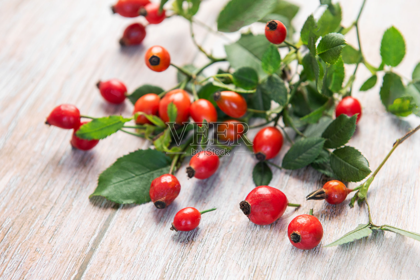 新鲜的玫瑰果放在乡村风格的白色桌子上照片摄影图片