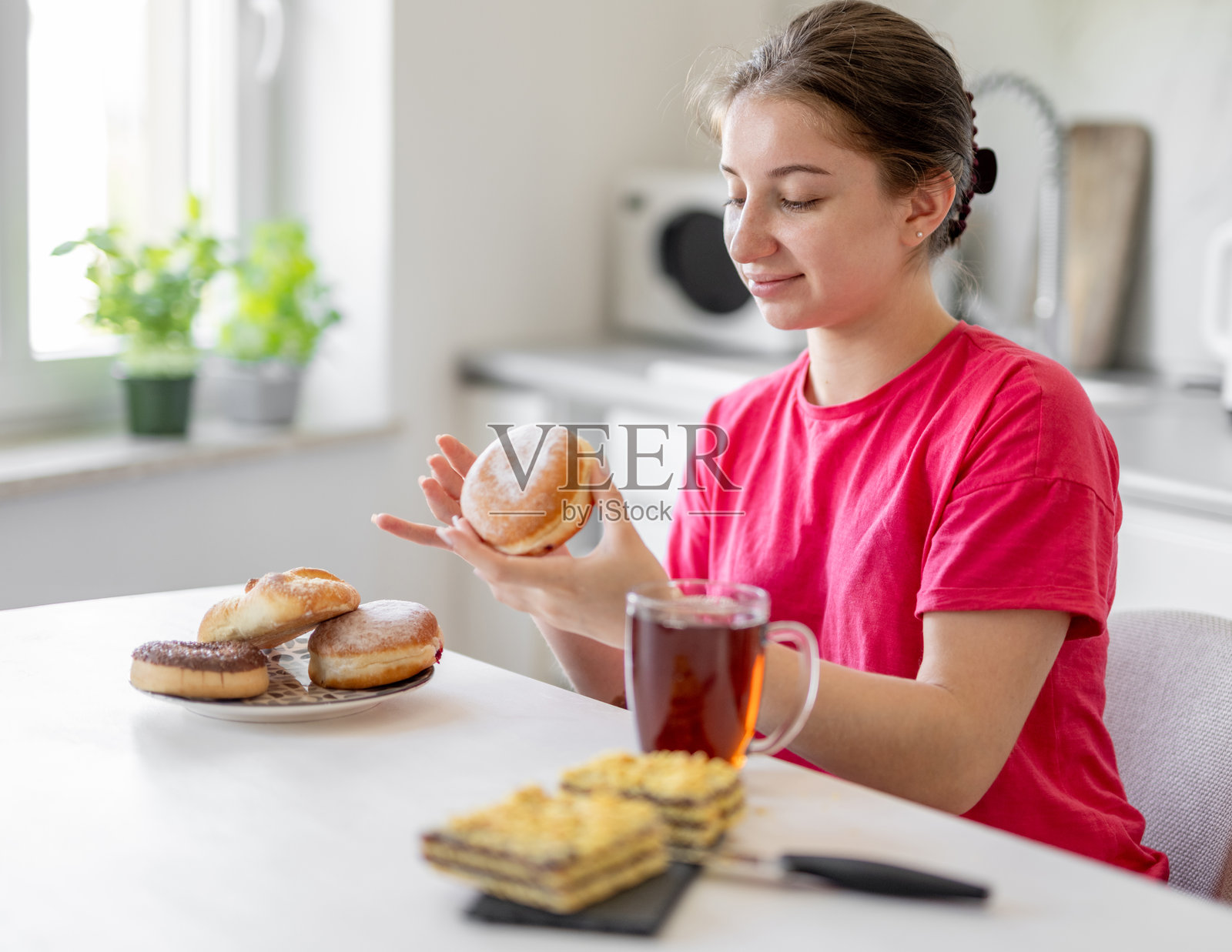 甜美的少女早餐吃甜甜圈照片摄影图片
