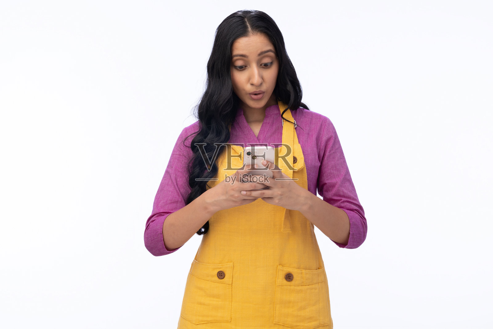 年轻女厨师在白色背景下使用手机的肖像照片照片摄影图片